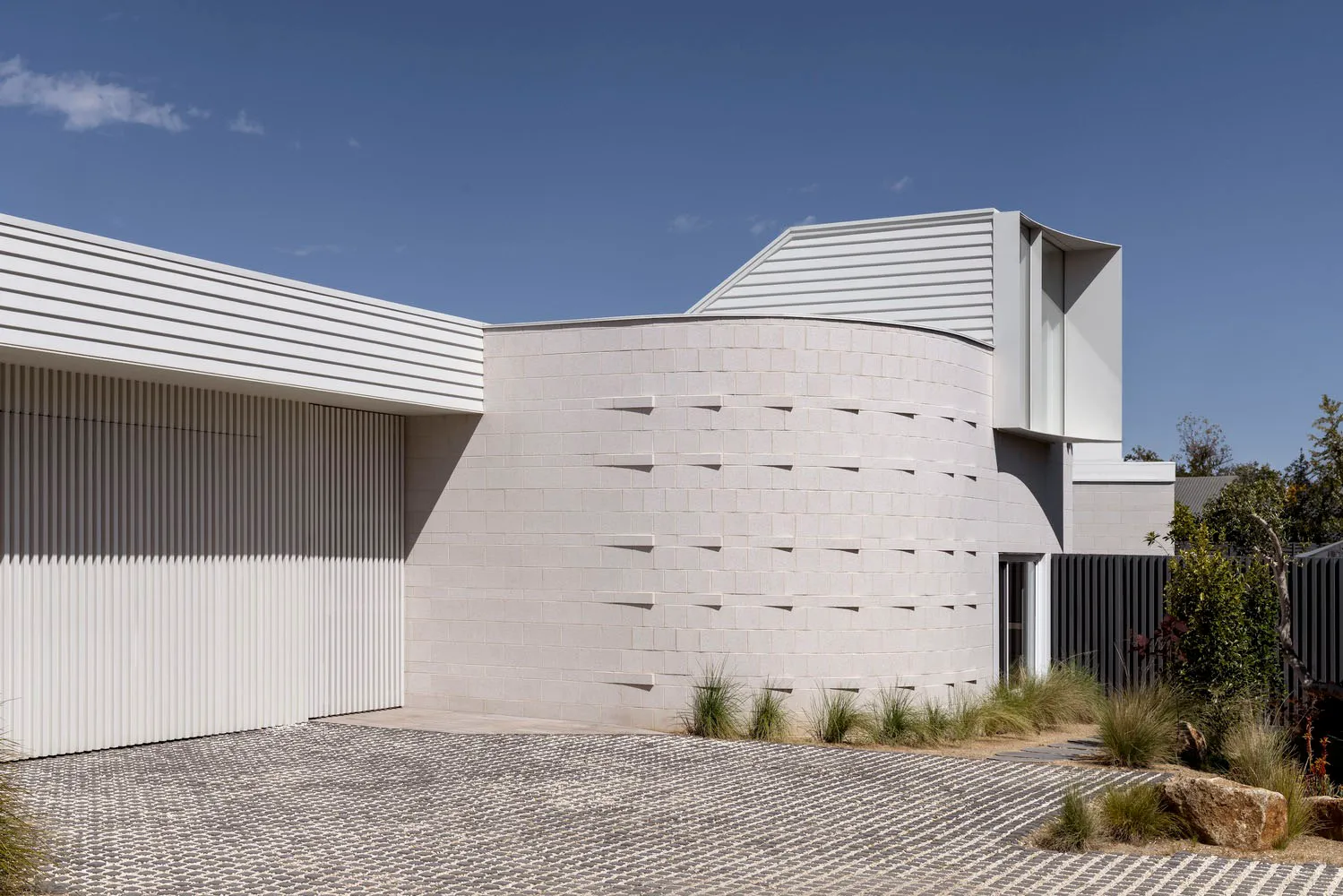 Modern, minimalist house exterior featuring brick material and geometric shapes.