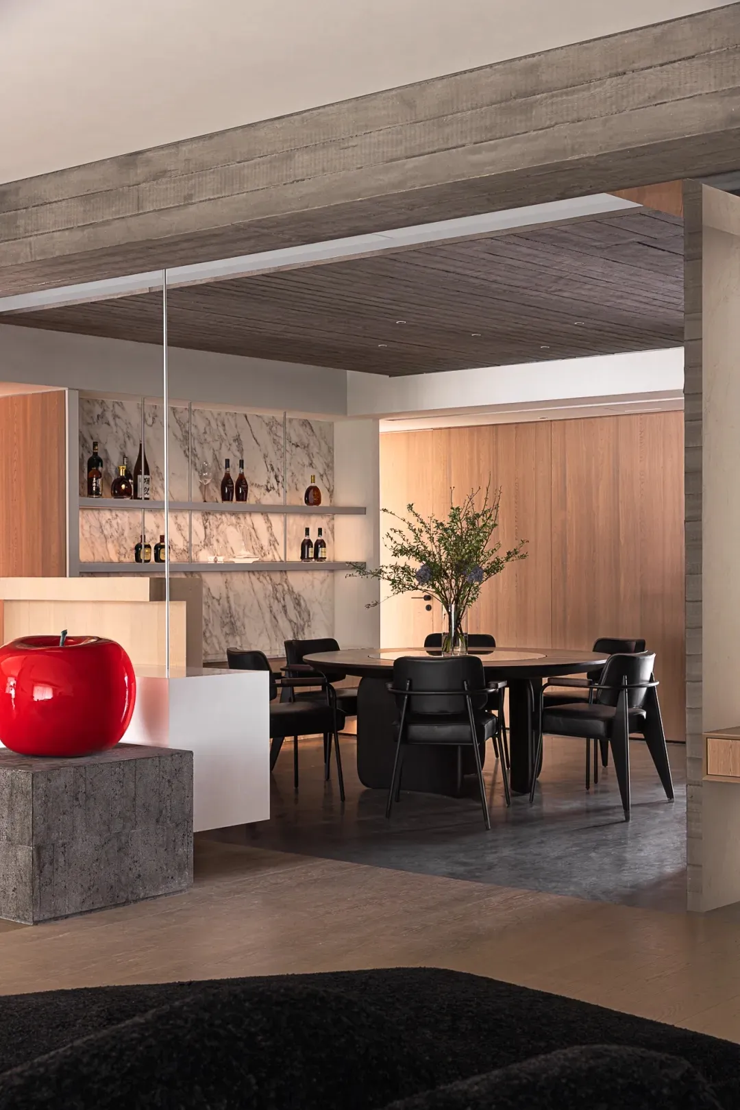 Modern minimalist dining room featuring marble bar, wooden floor, and concrete accents.