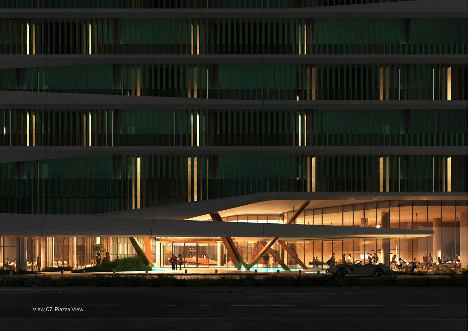 A modern hotel facade at night with metal cladding and glass columns.