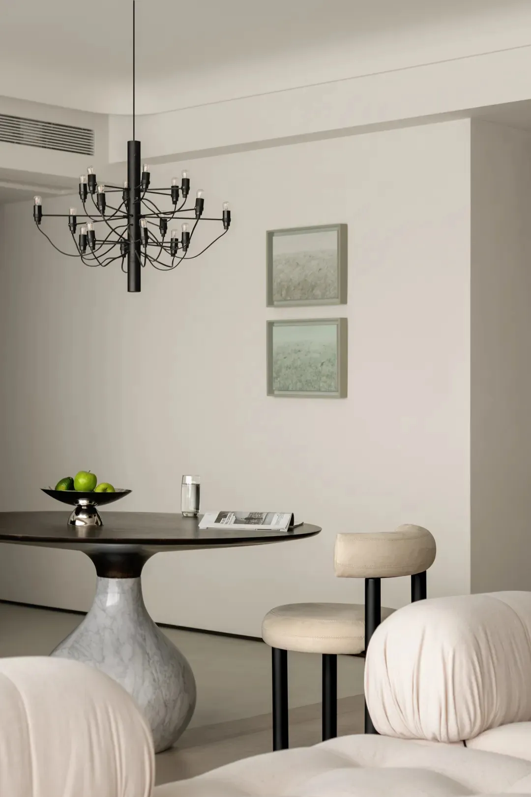 A minimalist apartment showcasing marble, metal, and upholstered furniture.
