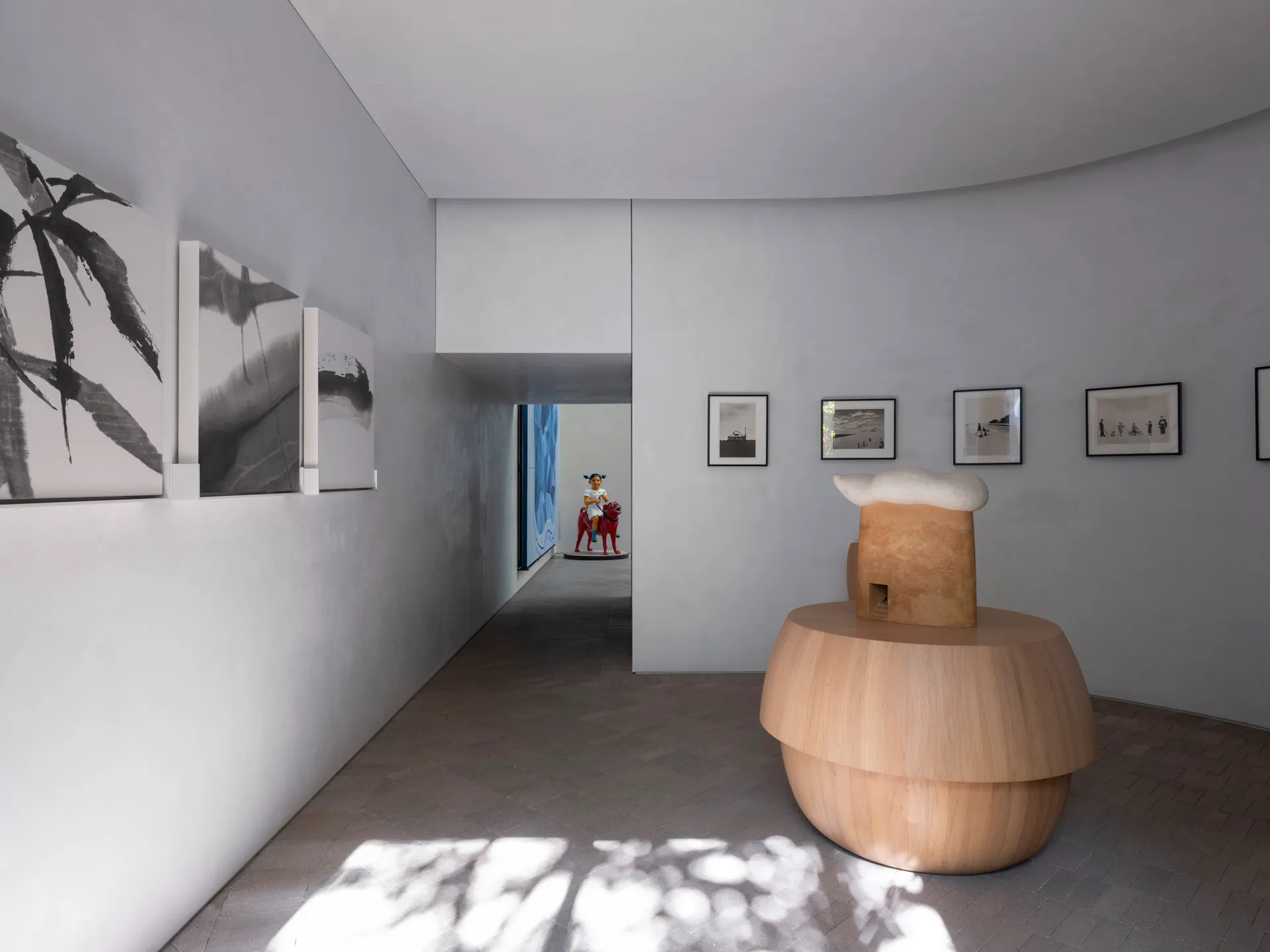 Minimalist art museum interior showcasing black and white pieces on light-colored walls.