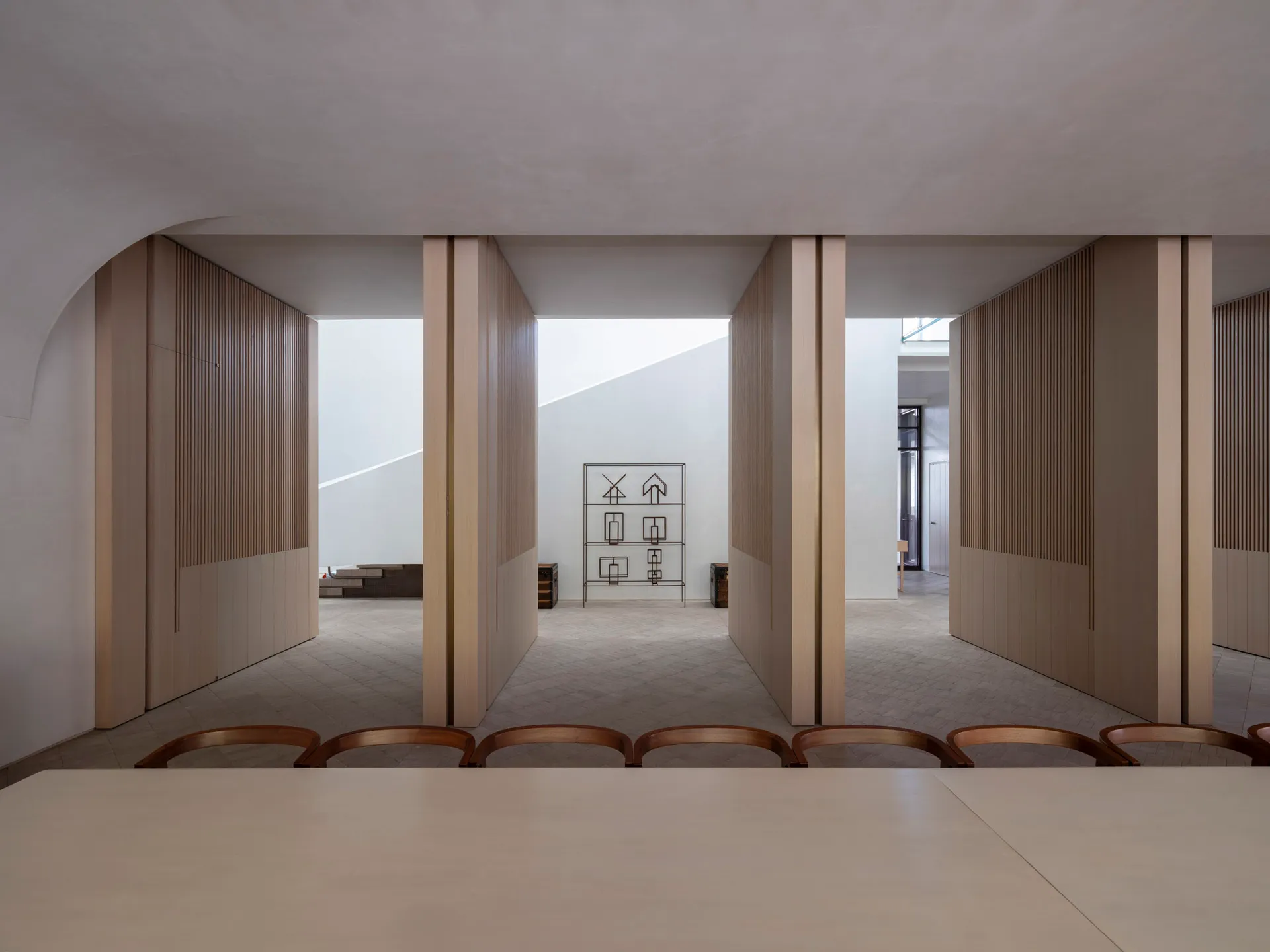 A minimalist interior with white walls and wooden elements.
