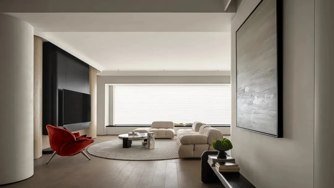 Modern living room with neutral tones, featuring a plush sofa and a sleek dining table with minimalist chairs.