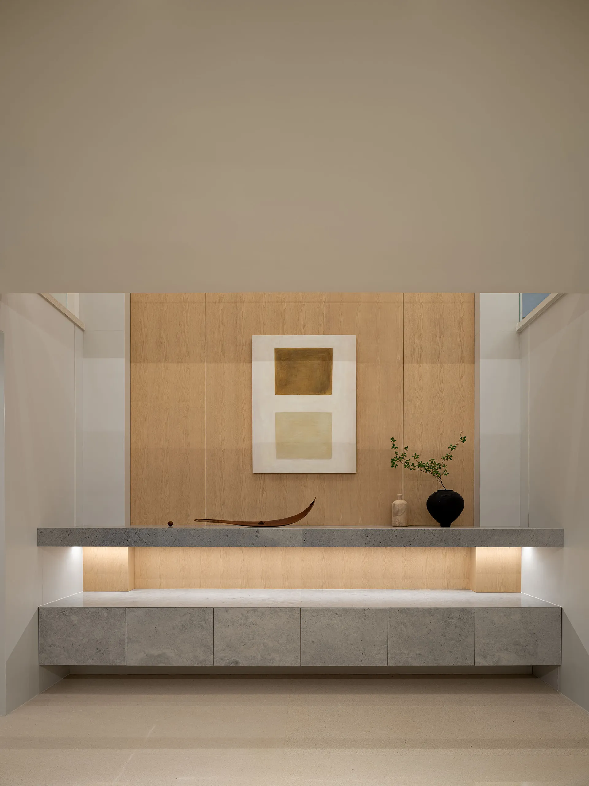Modern minimalist living room featuring a stone platform with a minimalist abstract painting, minimalistic decor, and a sleek