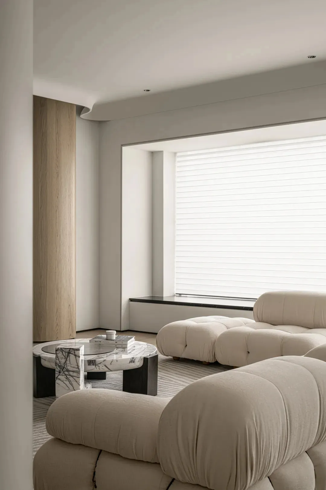 Modern minimalist living room with plush cushions and a large window