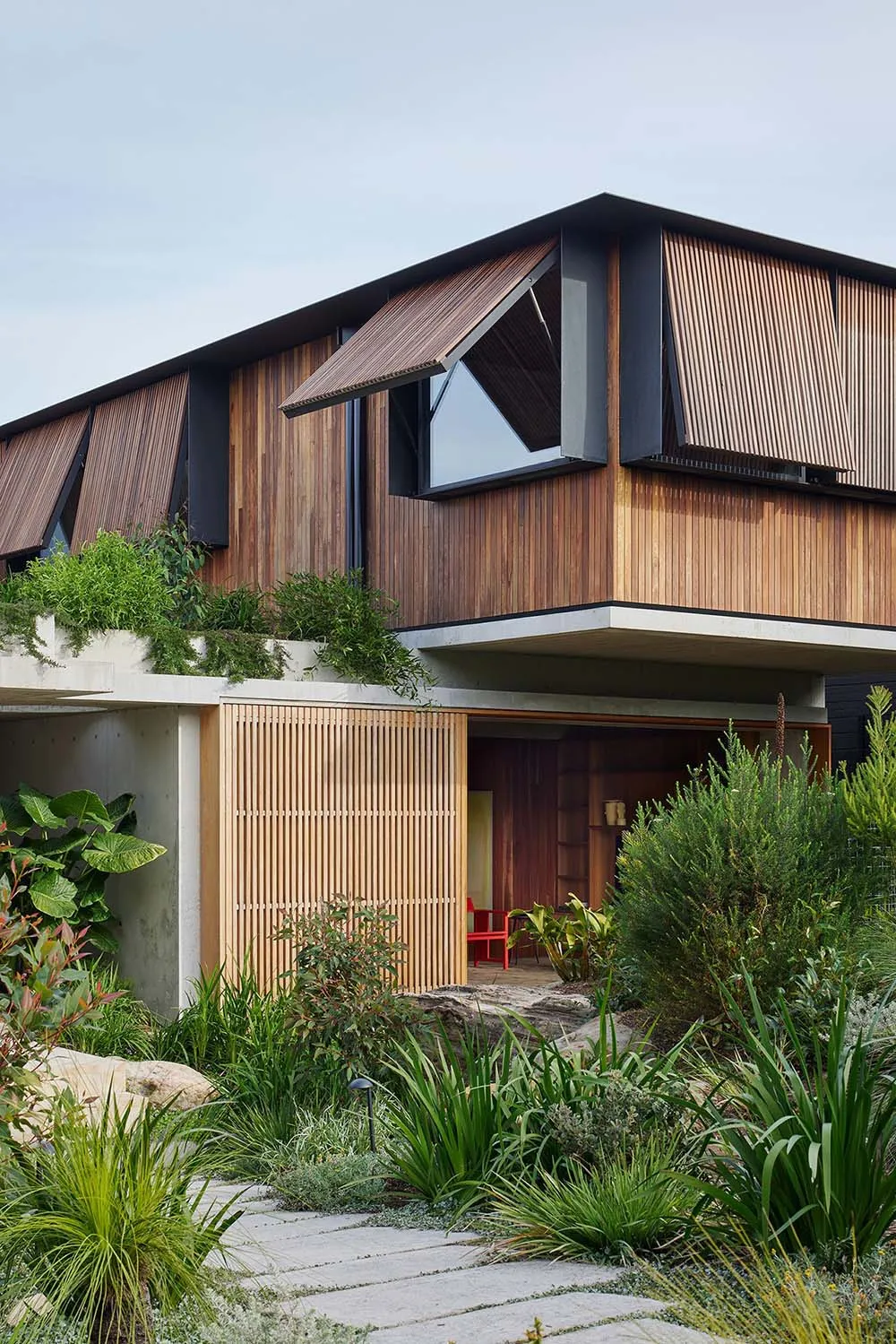 A modern house exterior featuring wooden panels and concrete elements.