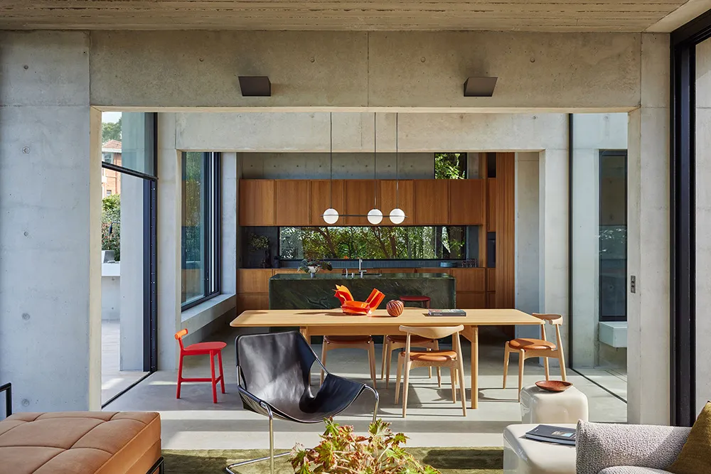 A modern kitchen with wood cabinets and a concrete floor.