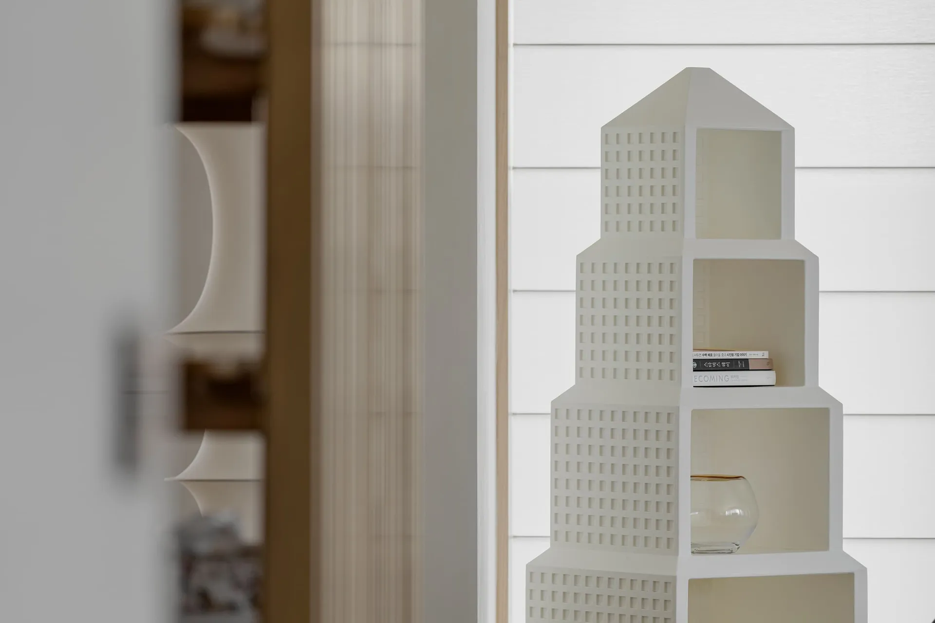 A modern, minimalist shelf with a decorative white design, featuring plastic material.