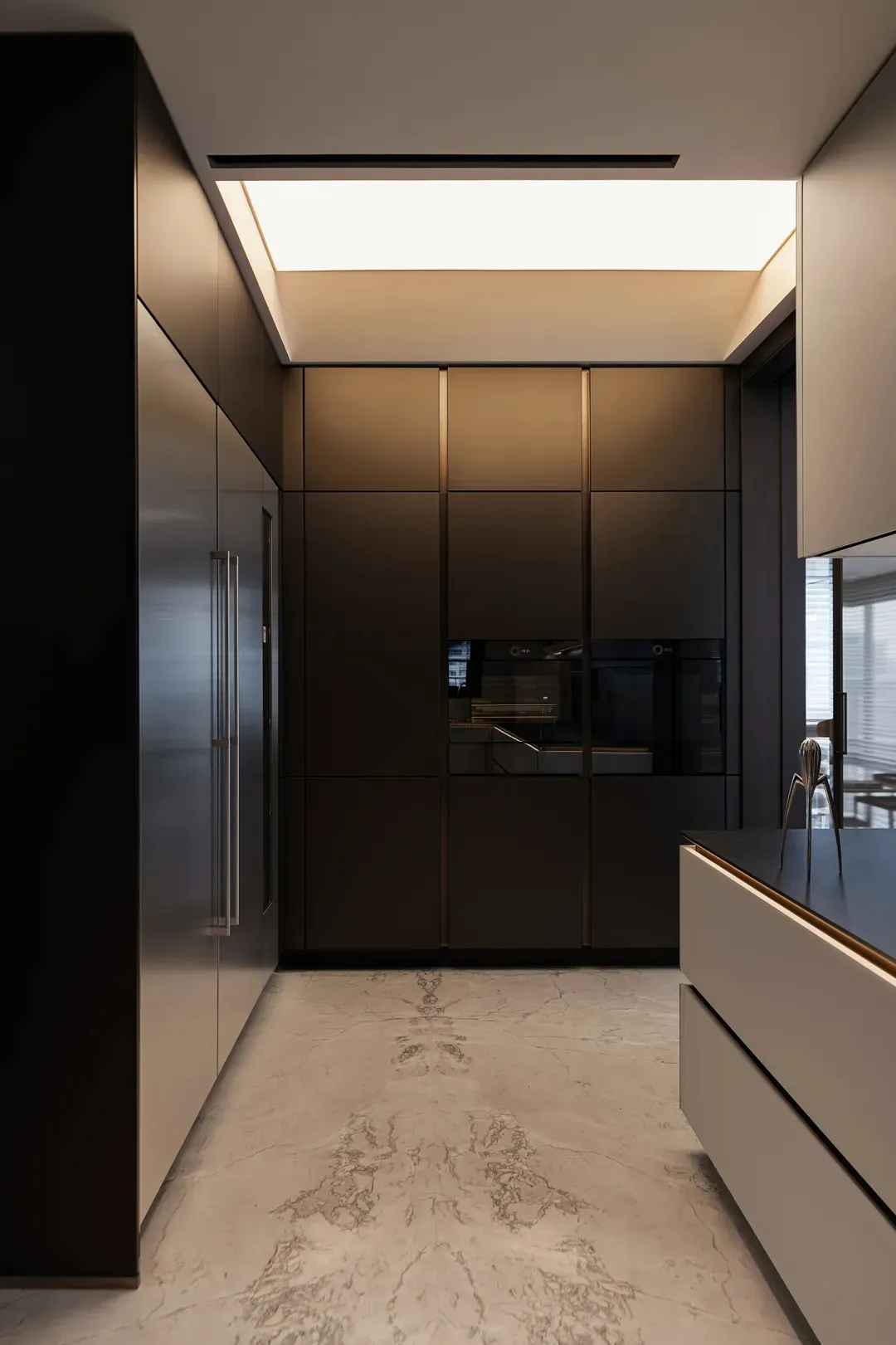 Modern, minimalist kitchen with metallic countertops and sleek, black cabinets.