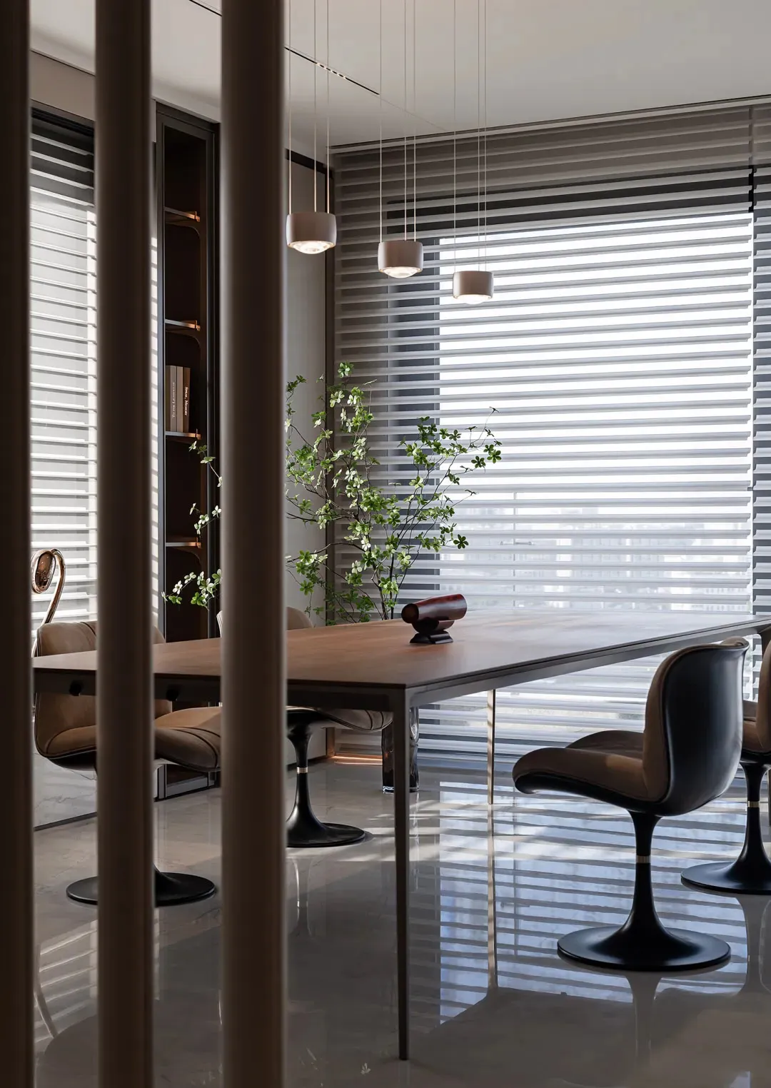 A modern dining room featuring a wooden table with black chairs, minimalist decor, and large windows with blinds.