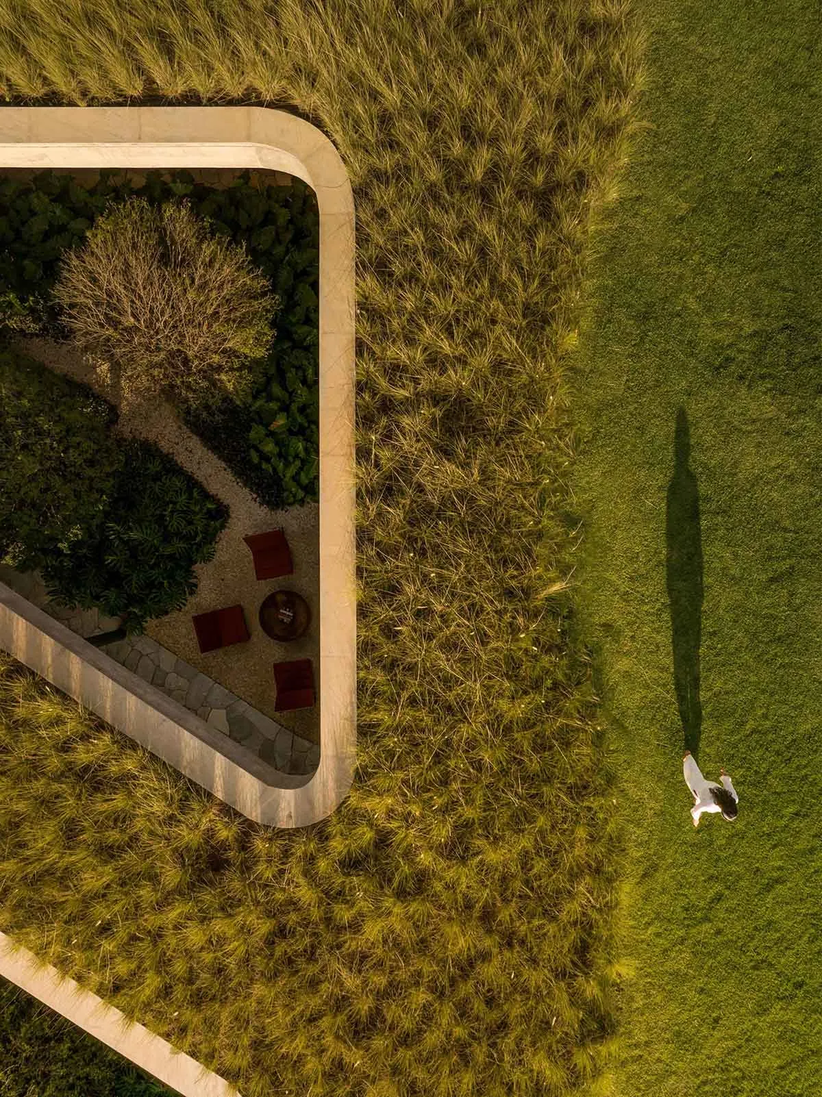 俯瞰現代景觀設計,綠色草坪由混凝土步道環繞,並設有小型花園區域