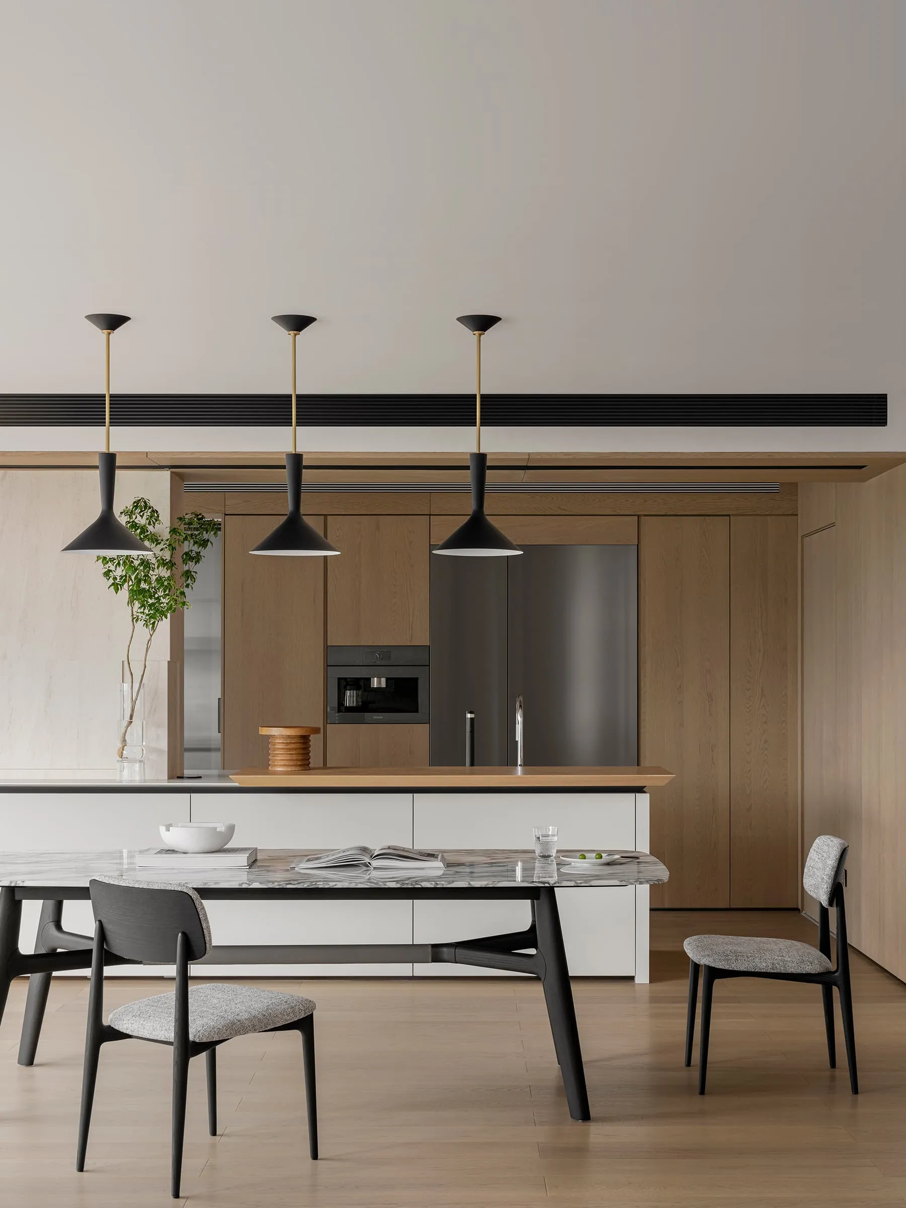 Modern kitchen and dining space featuring wood composite materials.