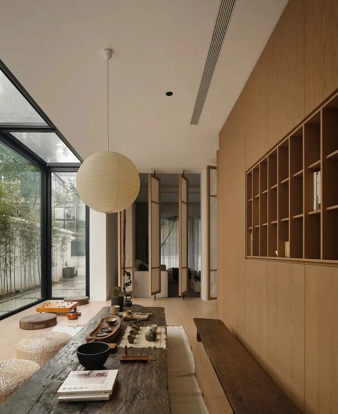 A minimalist interior design featuring wood, glass, and fabric elements.