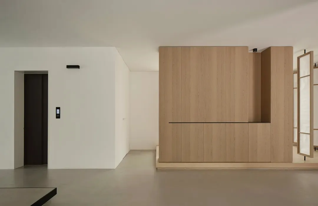 A minimalist residential space featuring wood and concrete materials.