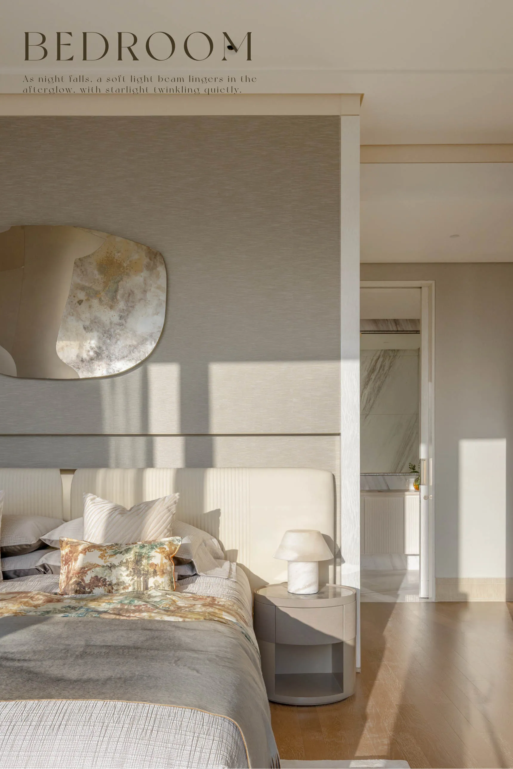 A modern, neutral-toned bedroom features a stone floor, marble accents, and a large bed with patterned pillows.