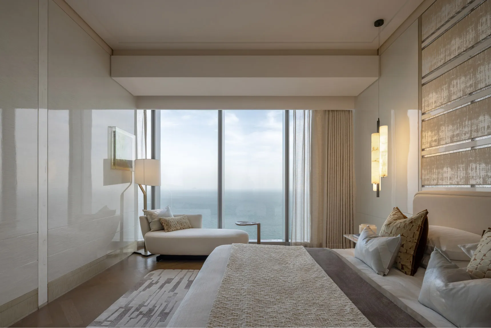 Modern bedroom featuring a large window with a view of the ocean.