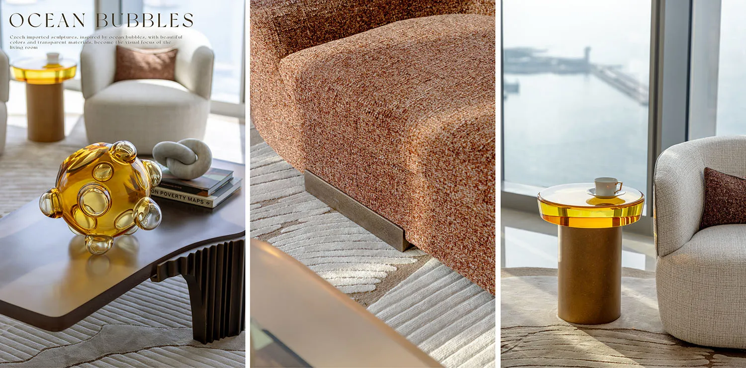 Modern living room featuring transparent glass sculptures, orange upholstered furniture, and a view of the ocean.