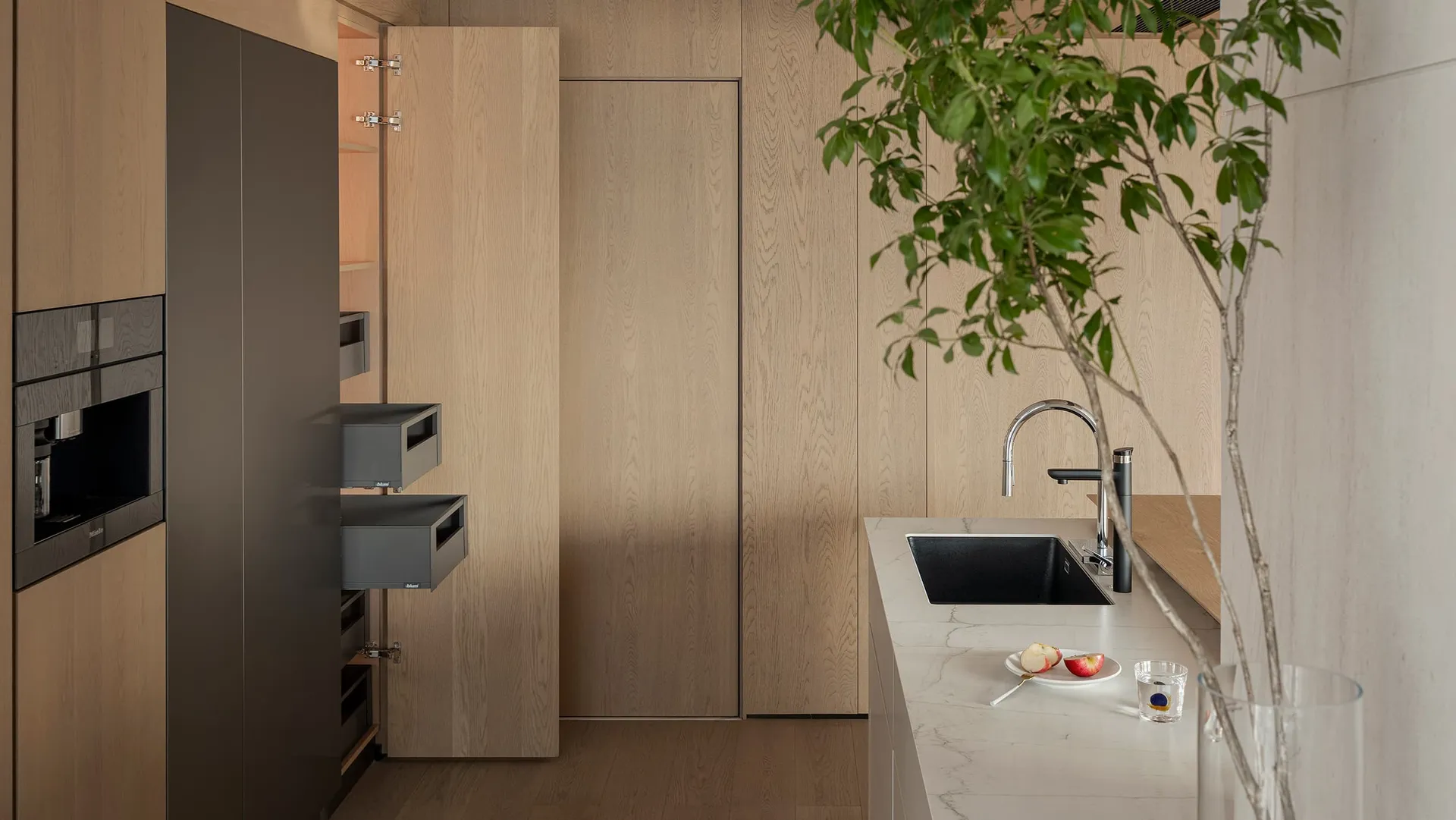 Modern minimalist kitchen featuring a marble countertop and wooden cabinets.