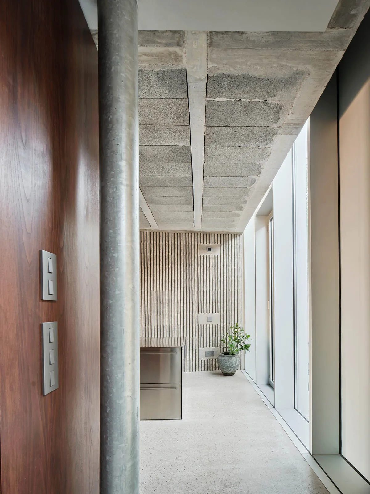 A modern industrial residential kitchen with concrete and steel elements.