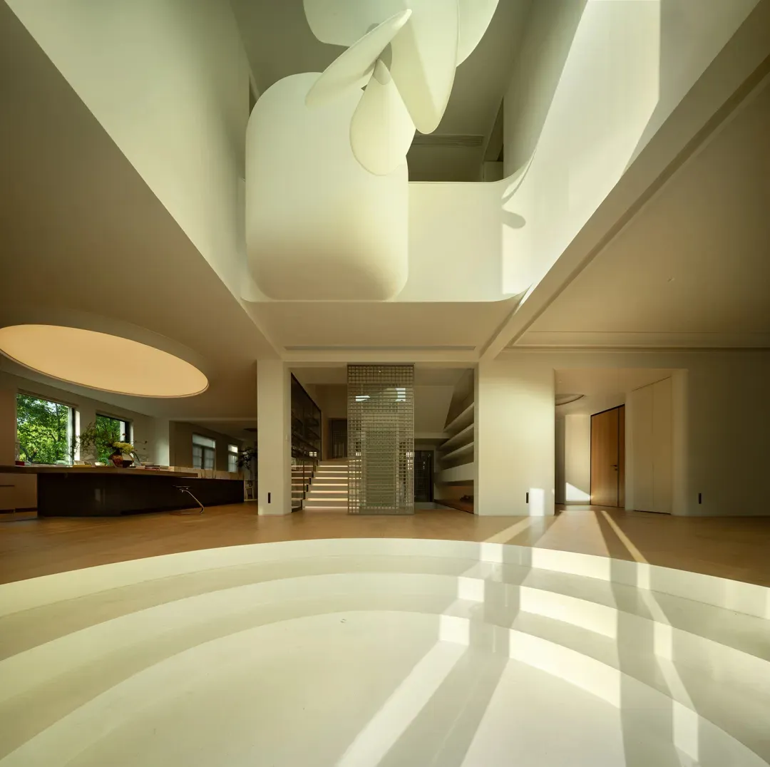 A modern interior space featuring a glass wall, white walls, and wooden flooring.