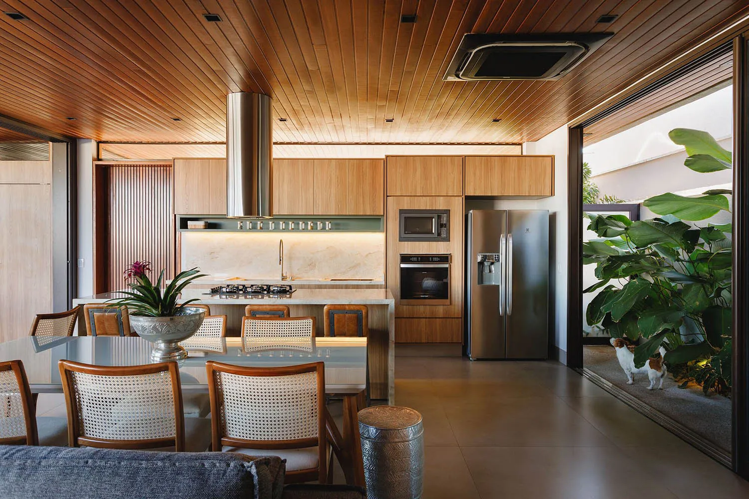 A modern kitchen with white marble countertops and wood cabinets.