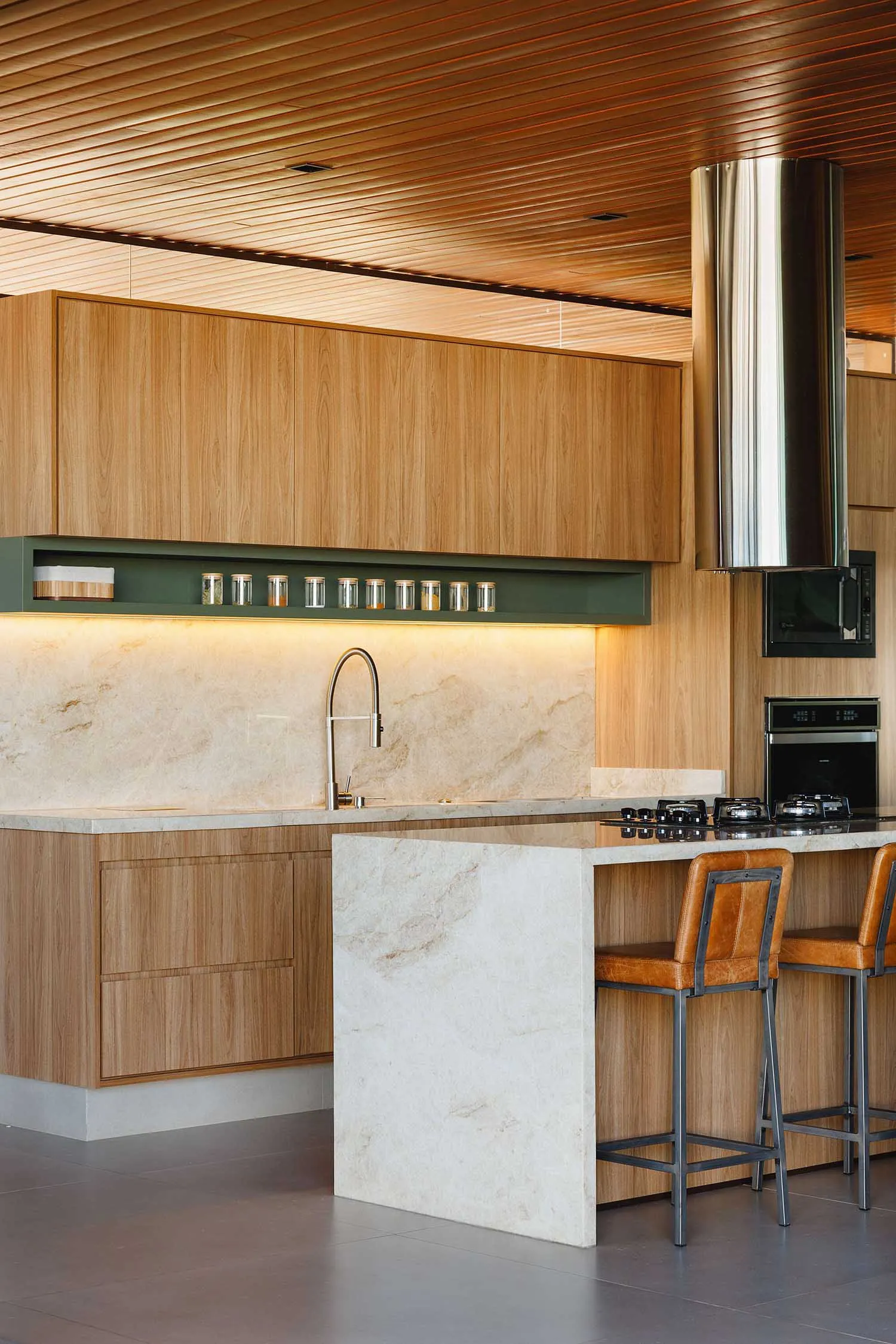 A modern kitchen interior featuring wooden cabinets and marble countertops.
