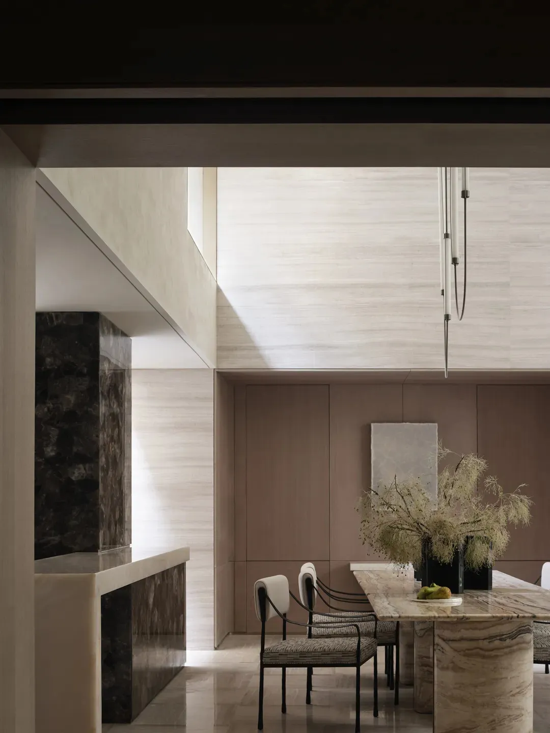 A modern residential interior space featuring a marble dining table and chairs.