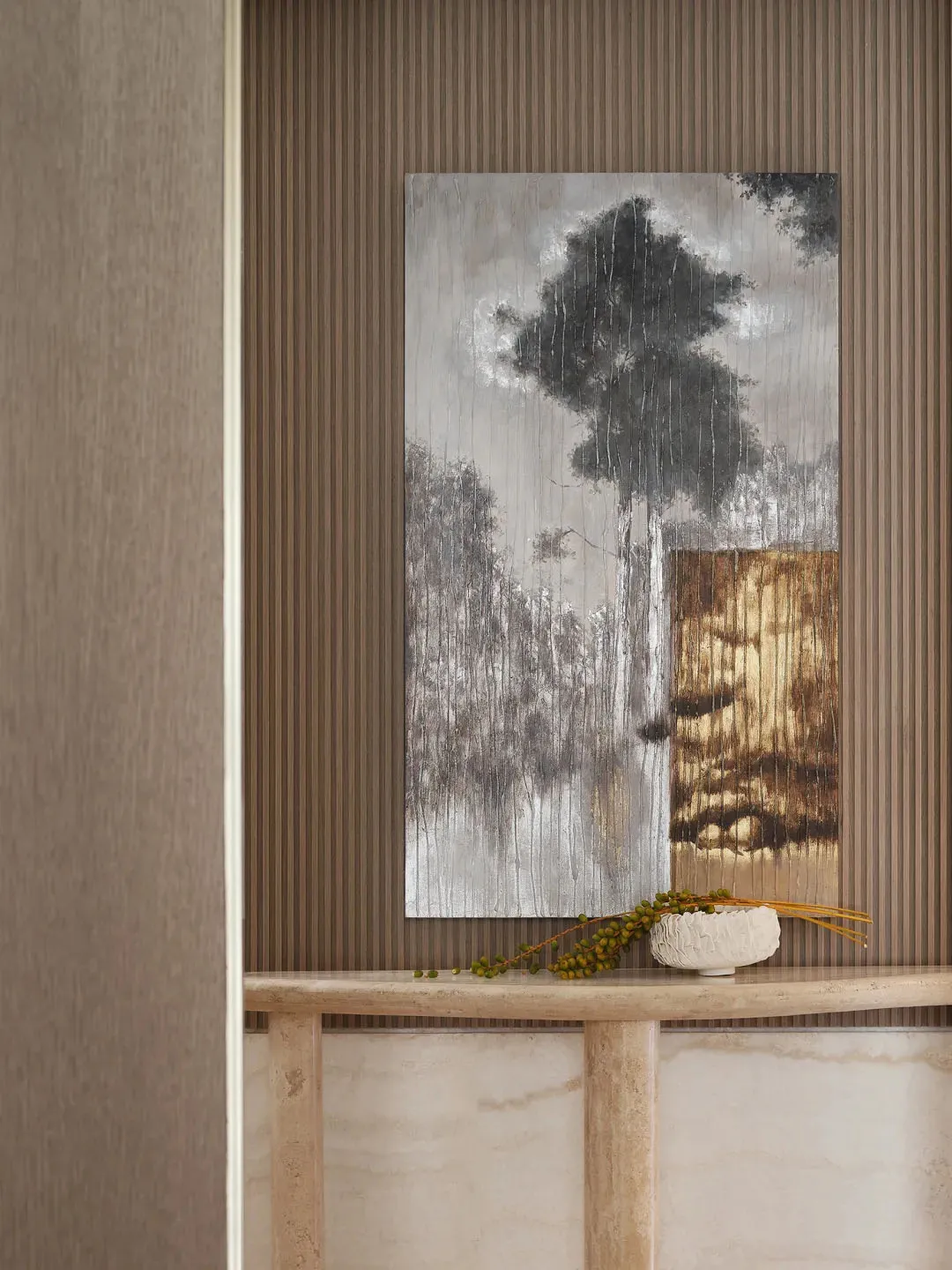 A modern entryway with an abstract painting featuring a tree and abstract shapes on a wooden surface.