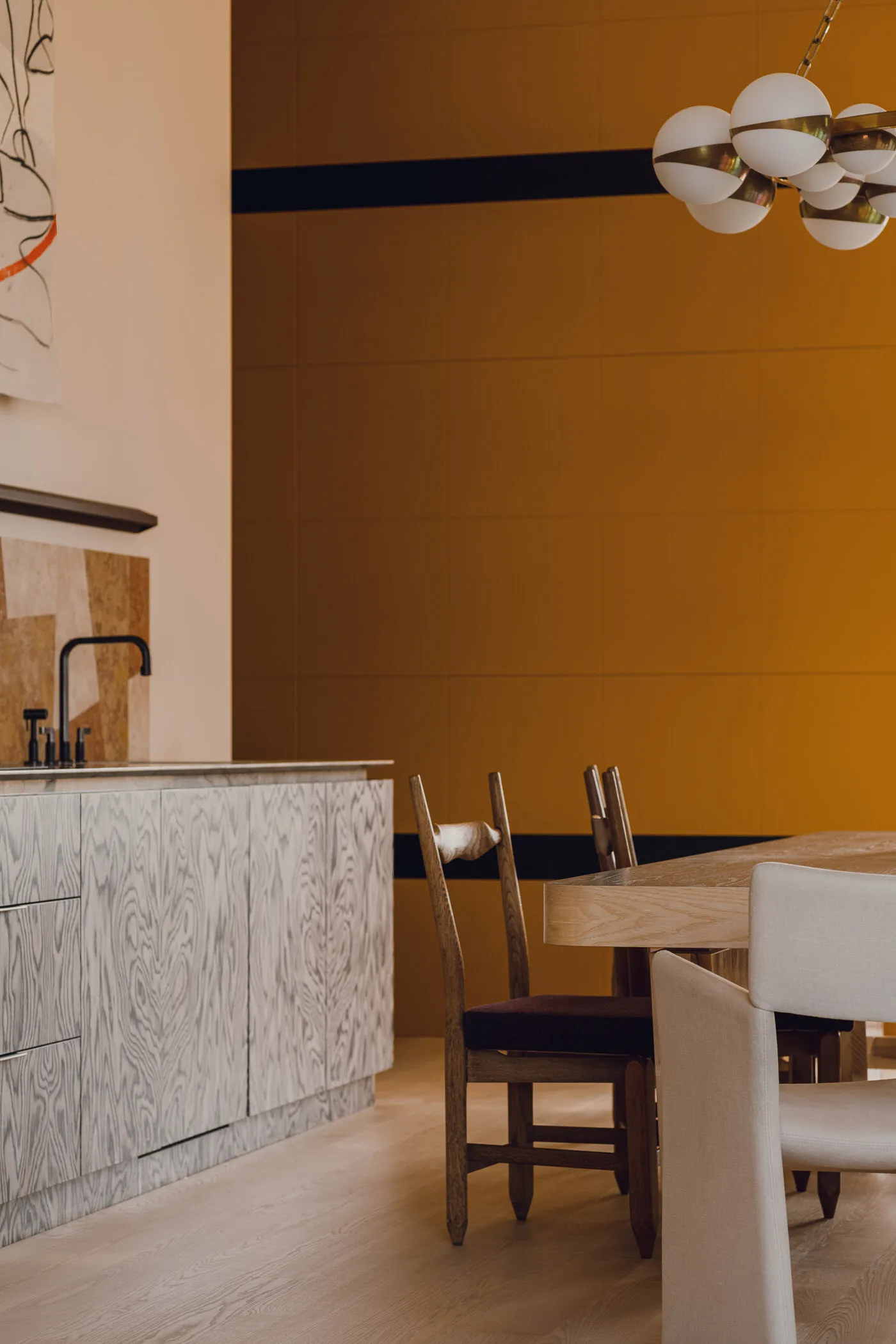 A modern kitchen with white marble countertops and wooden elements.