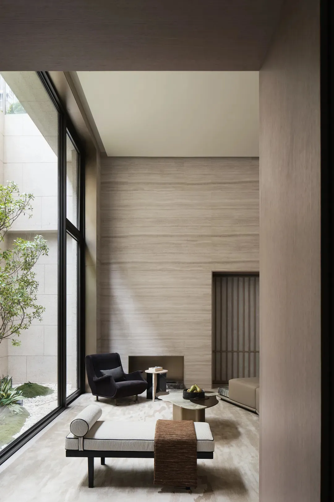 Modern living room featuring a glass wall, minimalist furniture, and a sleek design.