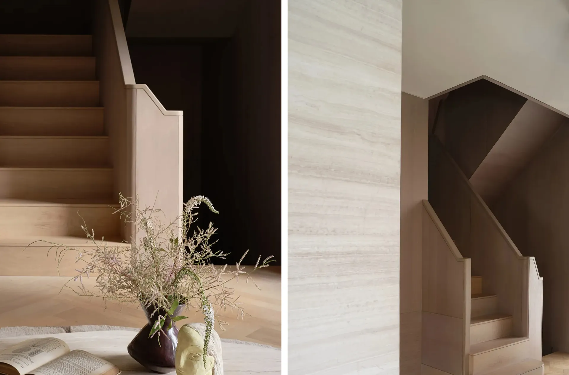 Decorative staircase featuring wooden steps and handrails with a vase of wildflowers and a sculpture on a table.