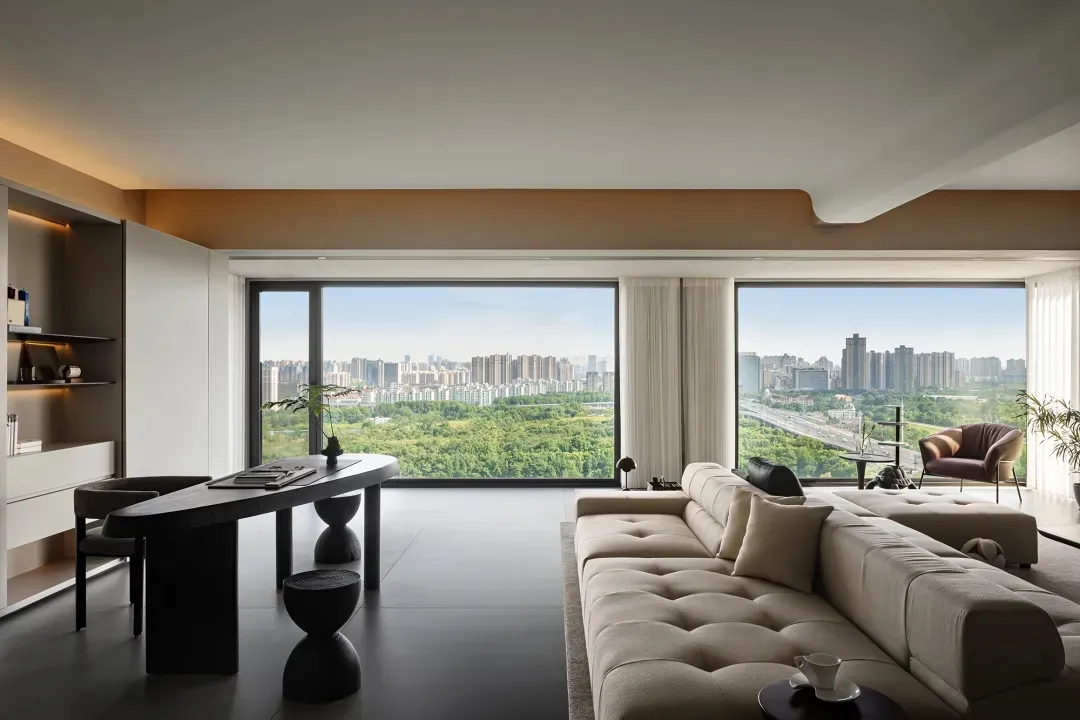 A modern, minimalist living room with large windows overlooking a cityscape.