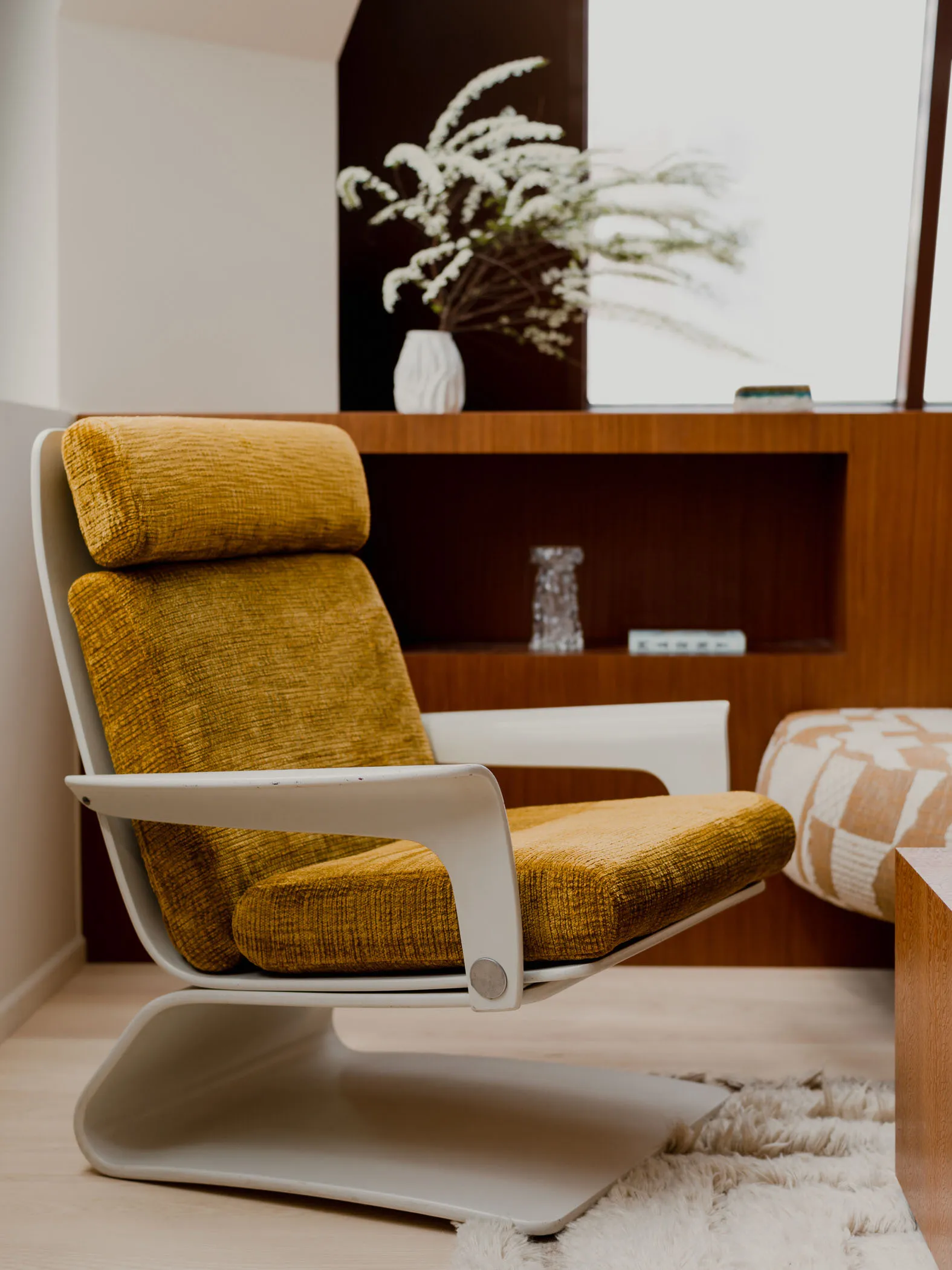 A minimalist modern living room with a yellow cushioned chair.