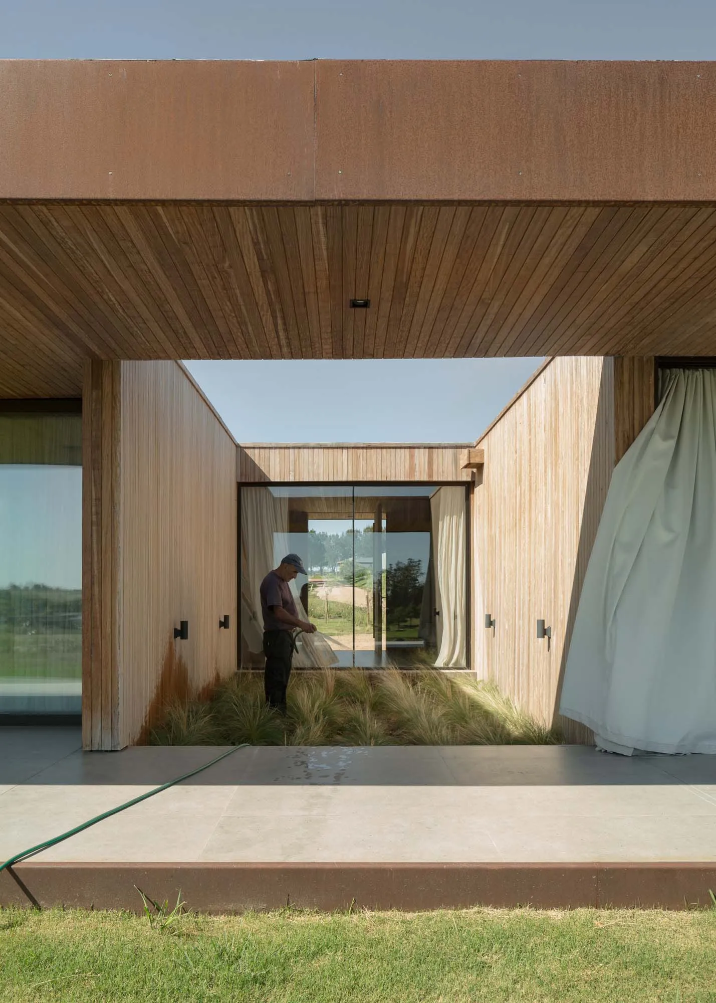 A modern residential house with wooden exterior and large glass window.