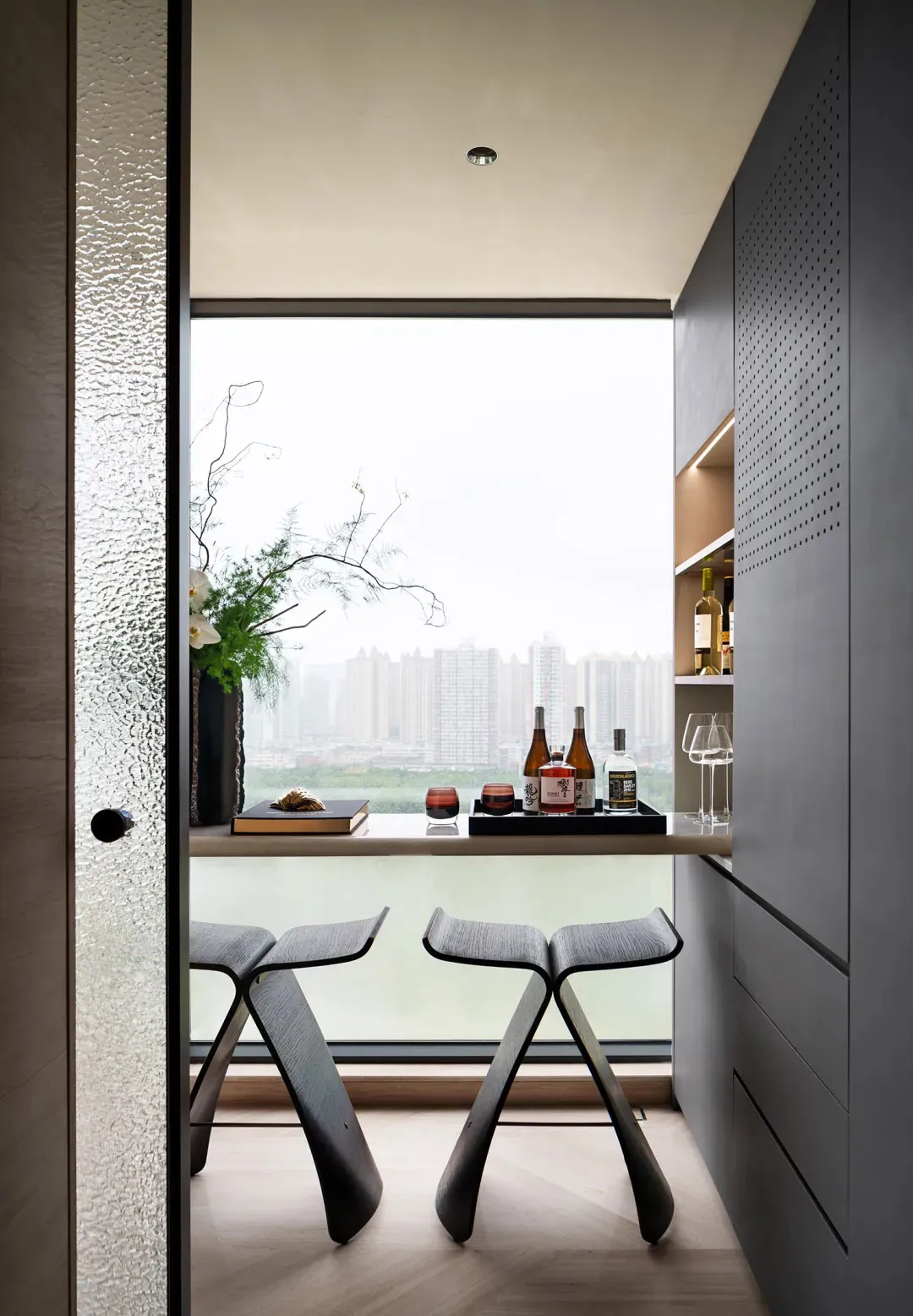 Modern bar stools with black legs and high silver backs.