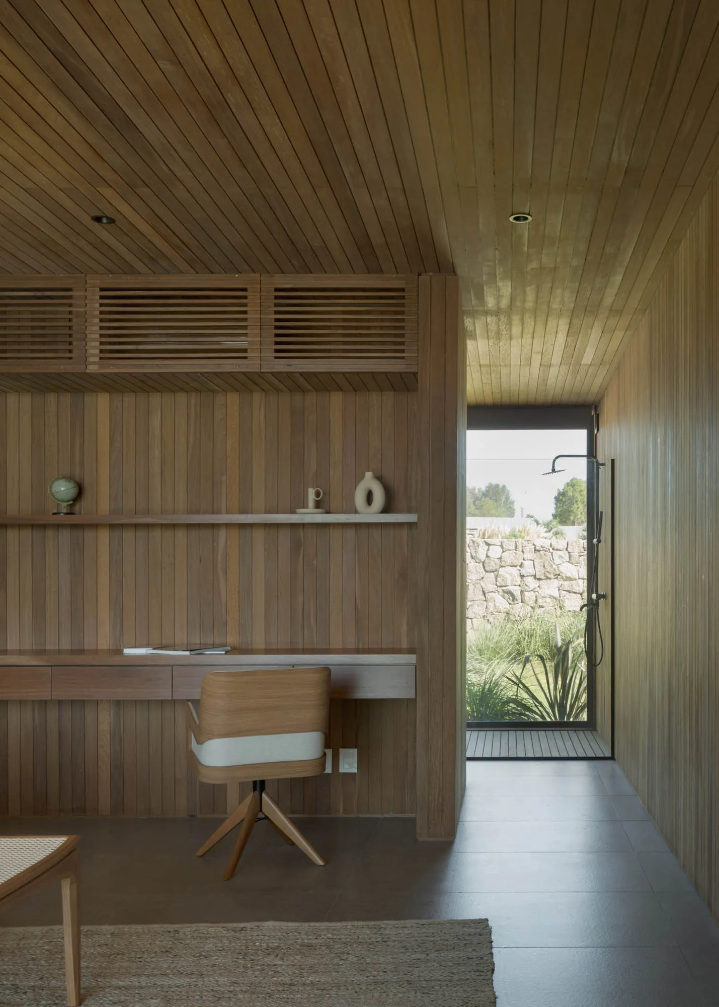 A modern home office featuring wooden walls and a desk area.