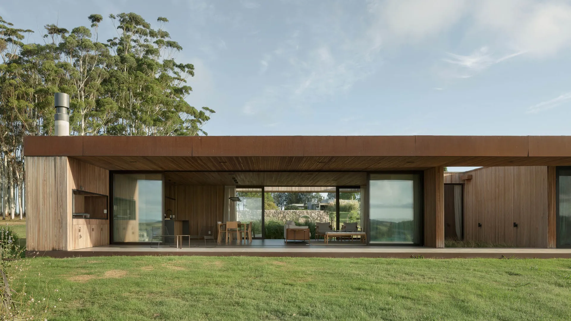 Modern house exterior featuring a flat roof and large windows, constructed with wood.