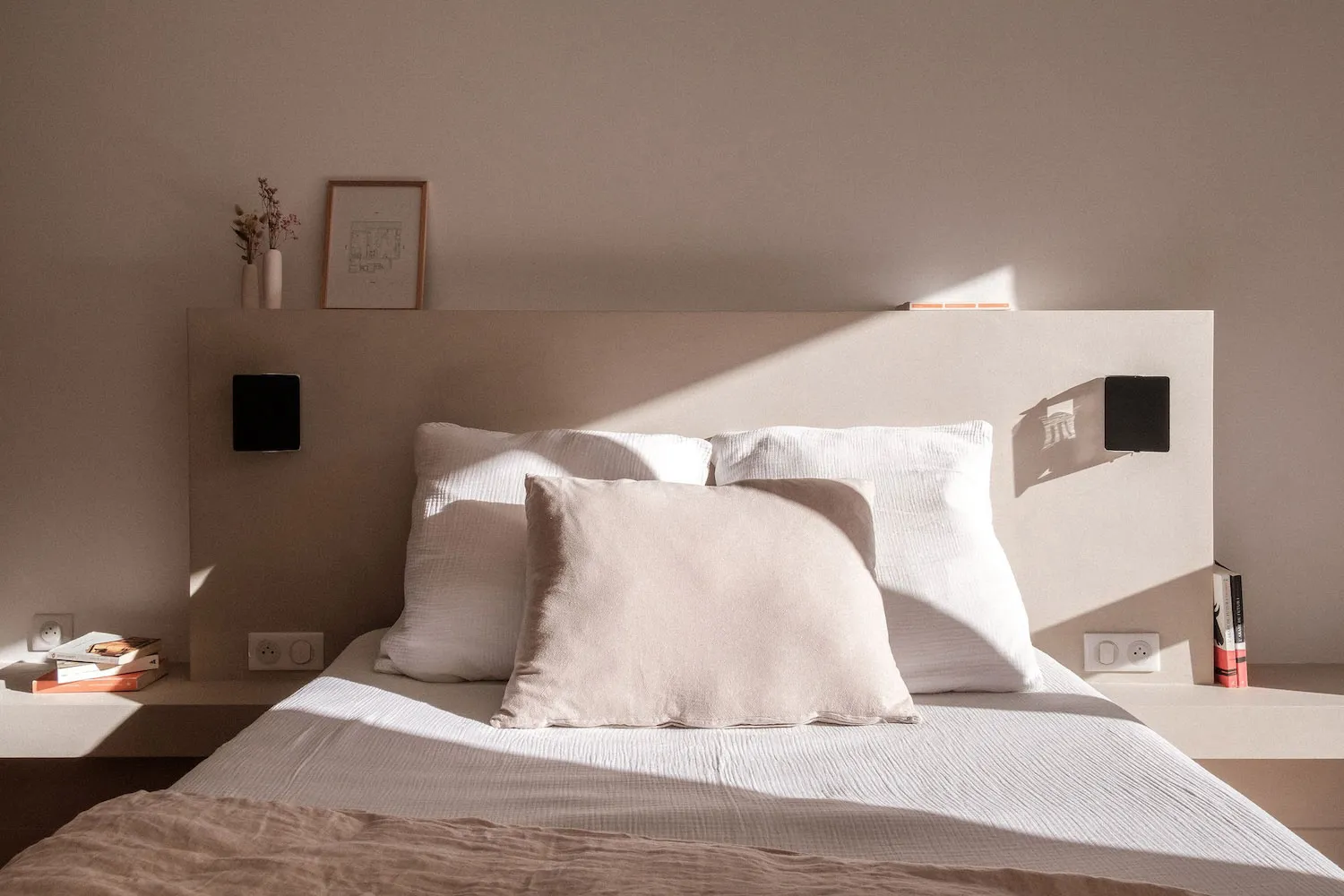 A serene, minimalist bedroom featuring soft textiles and wooden elements.
