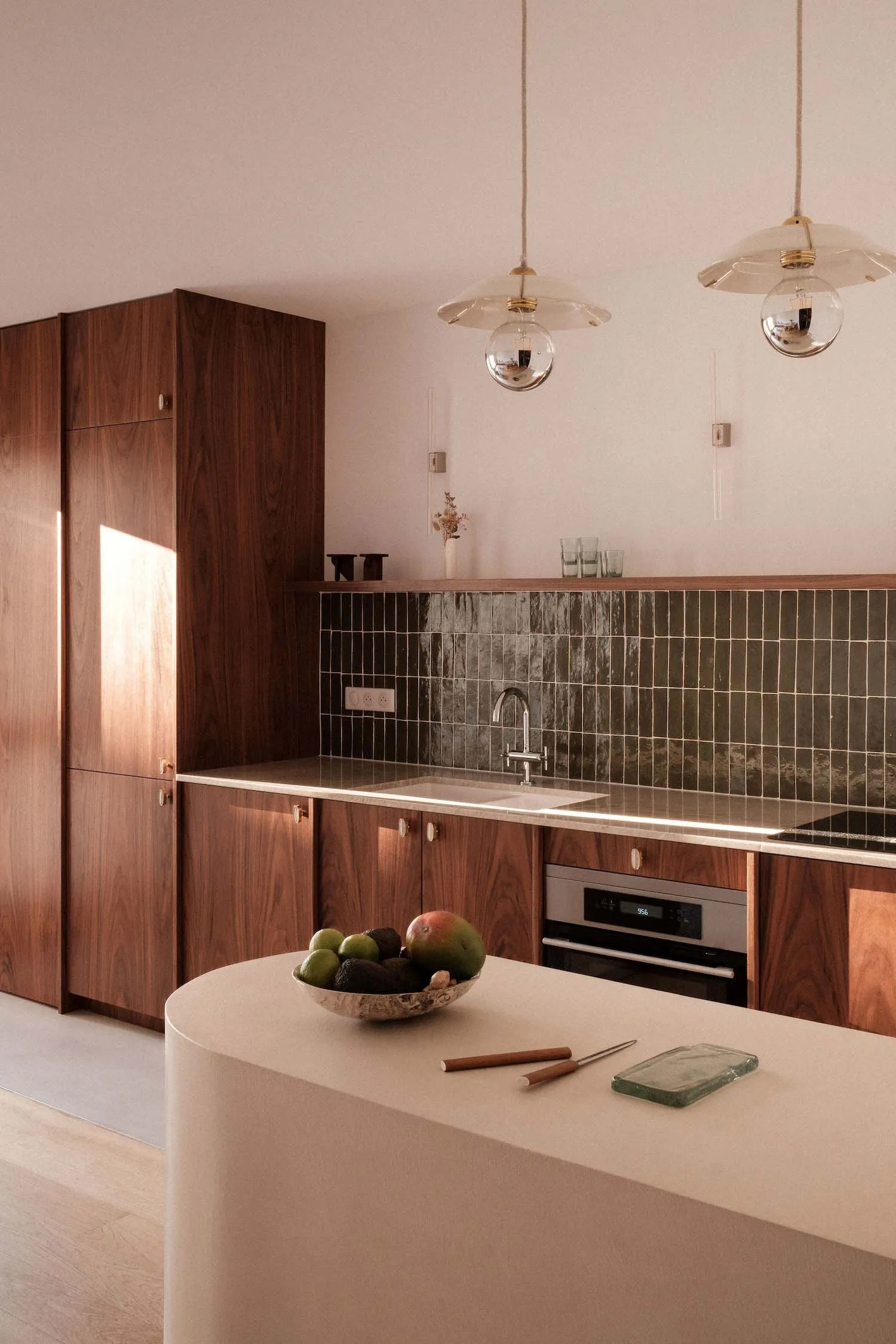 A modern kitchen with wooden cabinets, a marble countertop, and a backsplash of dark tiles.