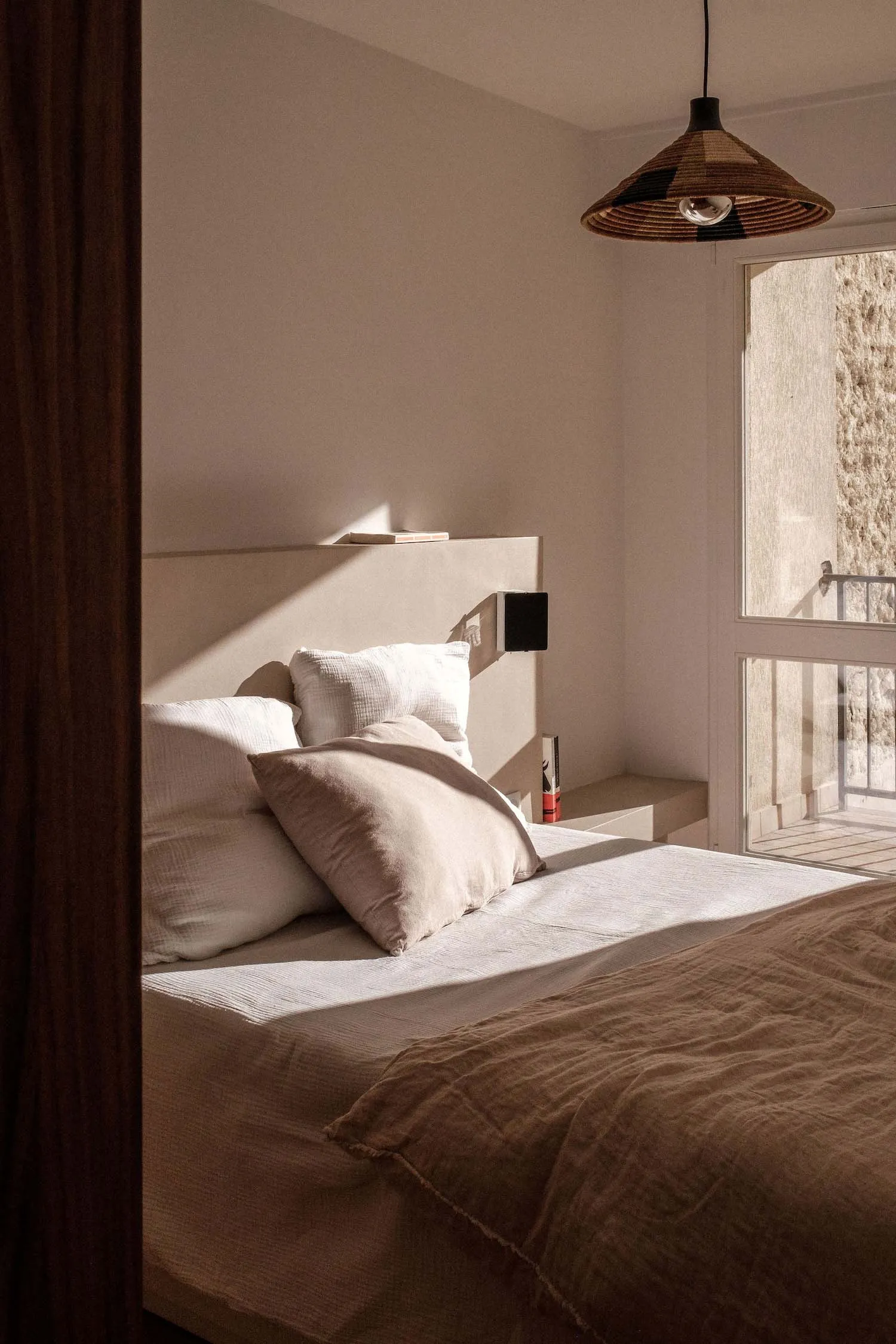A minimalist bedroom featuring soft textiles and natural light.