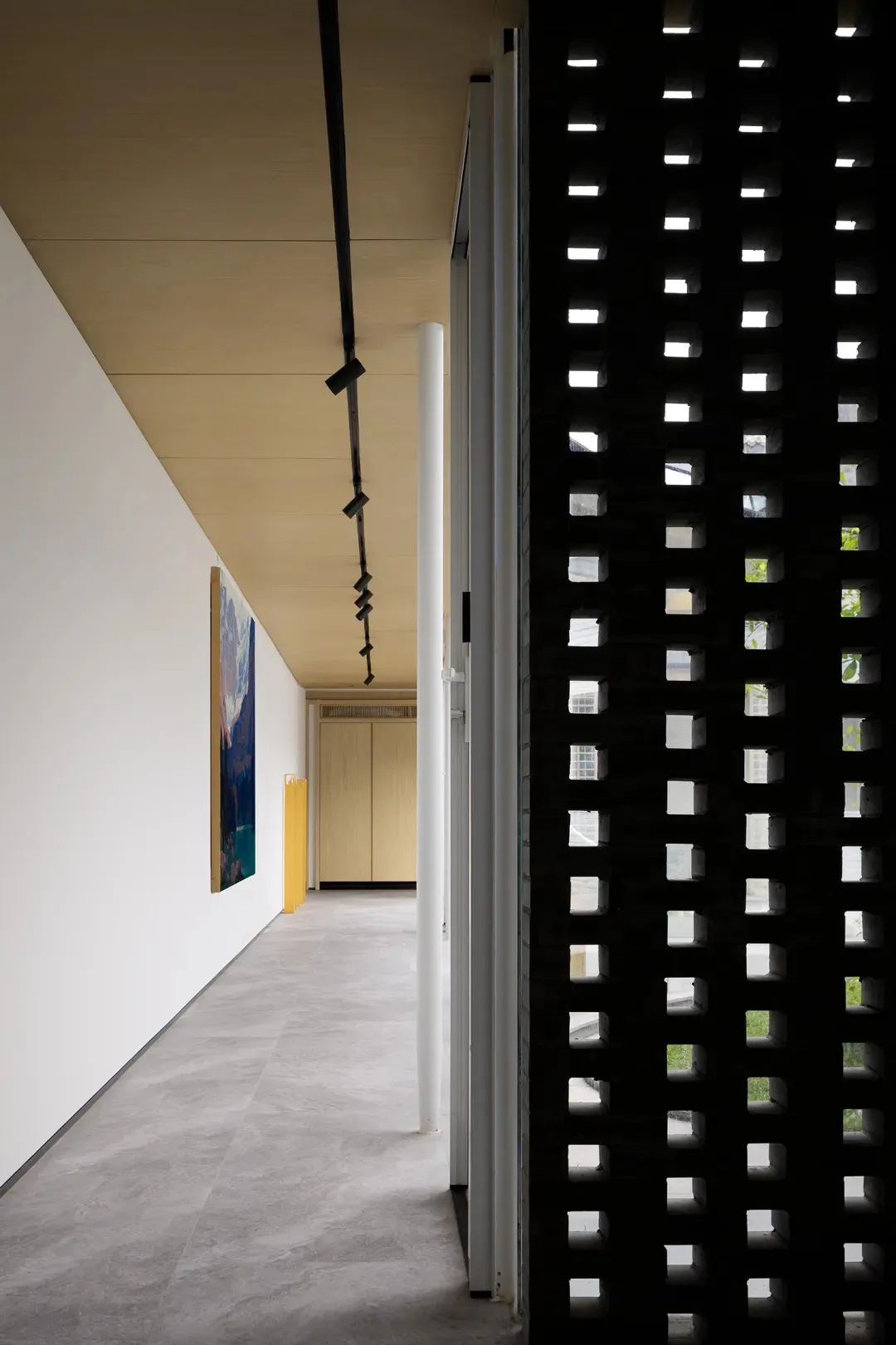 A modern bedroom featuring minimalist design with concrete flooring and walls.