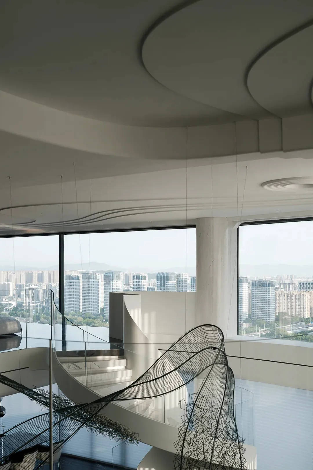 Modern interior space featuring glass and concrete walls with a cityscape view