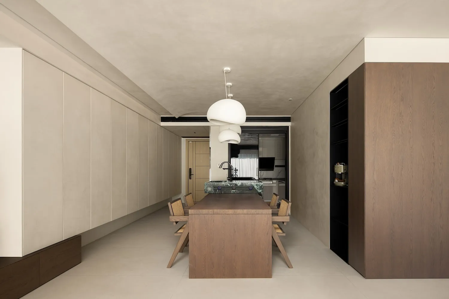 Modern kitchen and dining area with wooden table, marble countertop, and white pendant lights.