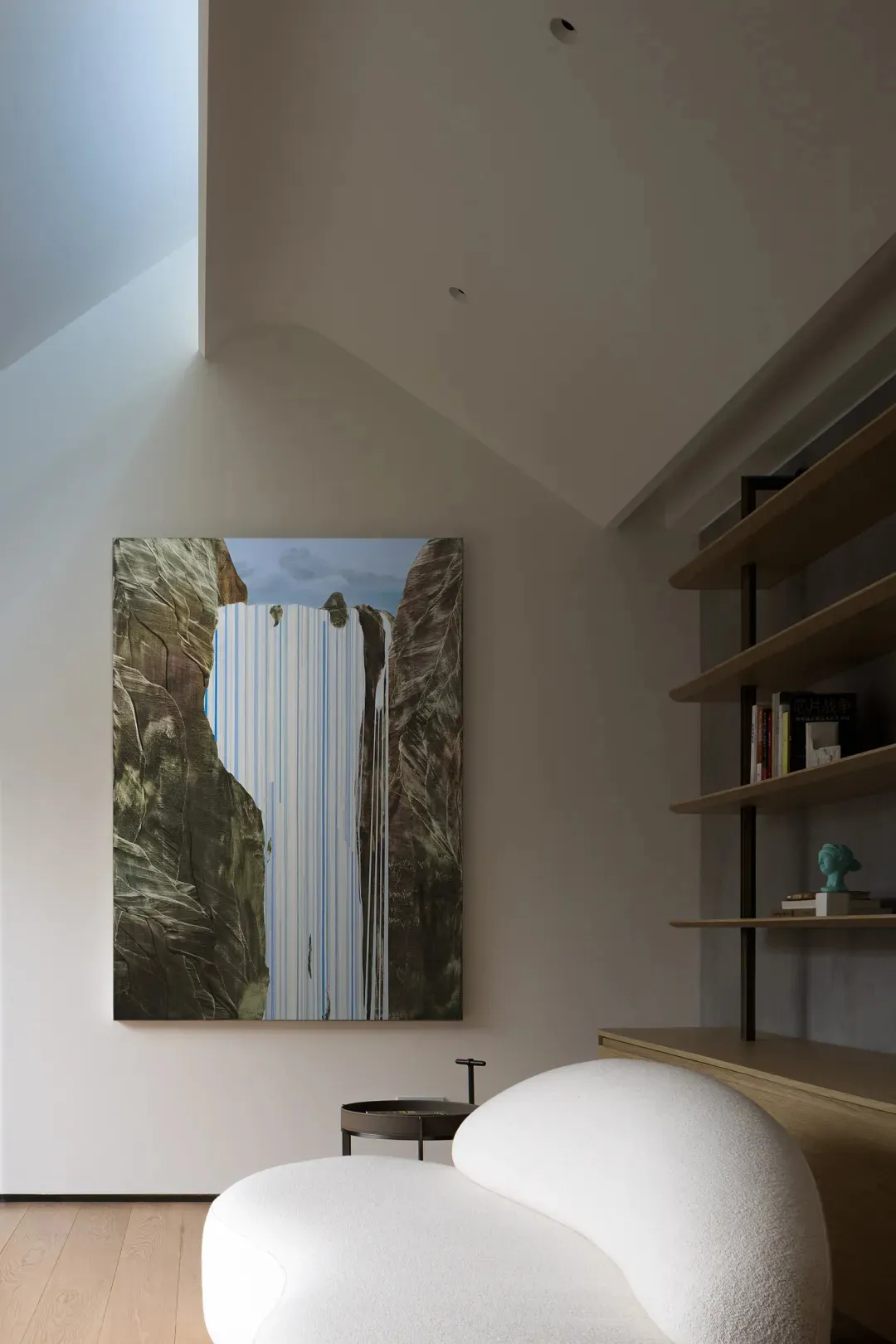 A modern living room with a large, abstract painting hanging on the wall.