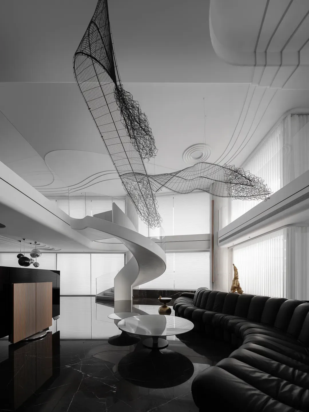 A modern living room featuring sleek black leather furniture and metal decorative elements.