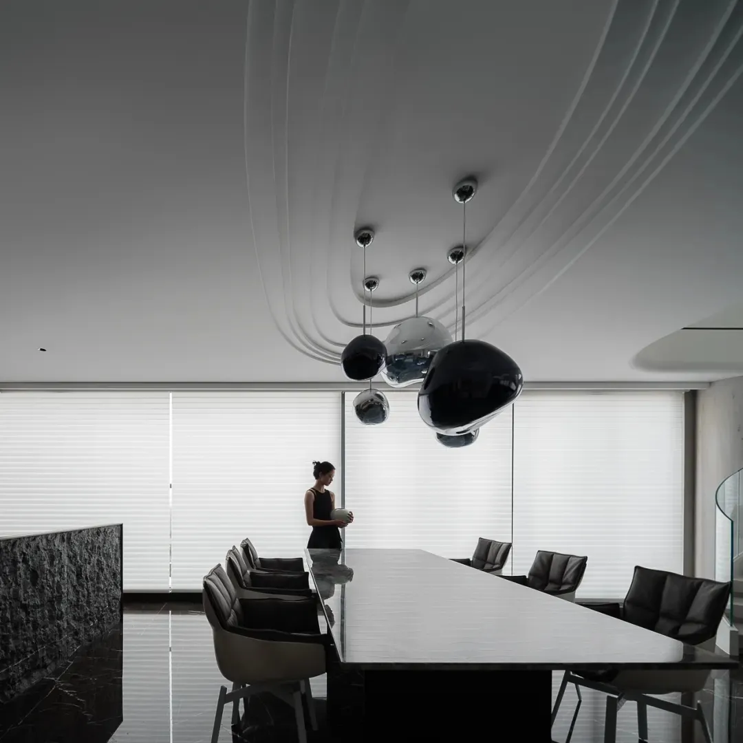 A modern, minimalist office space featuring glass, concrete, and steel elements.