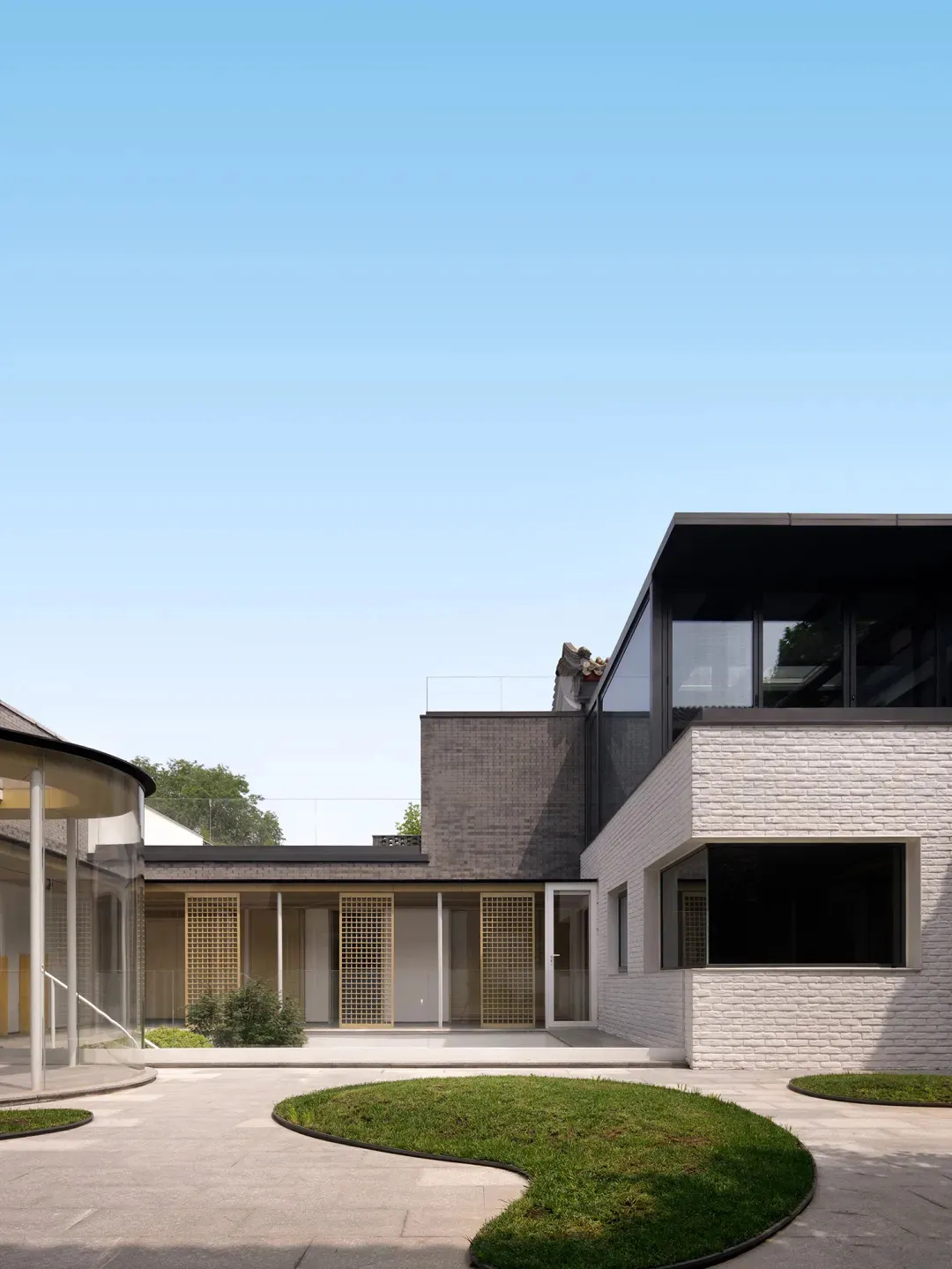 A modern residential exterior featuring brick and concrete materials.