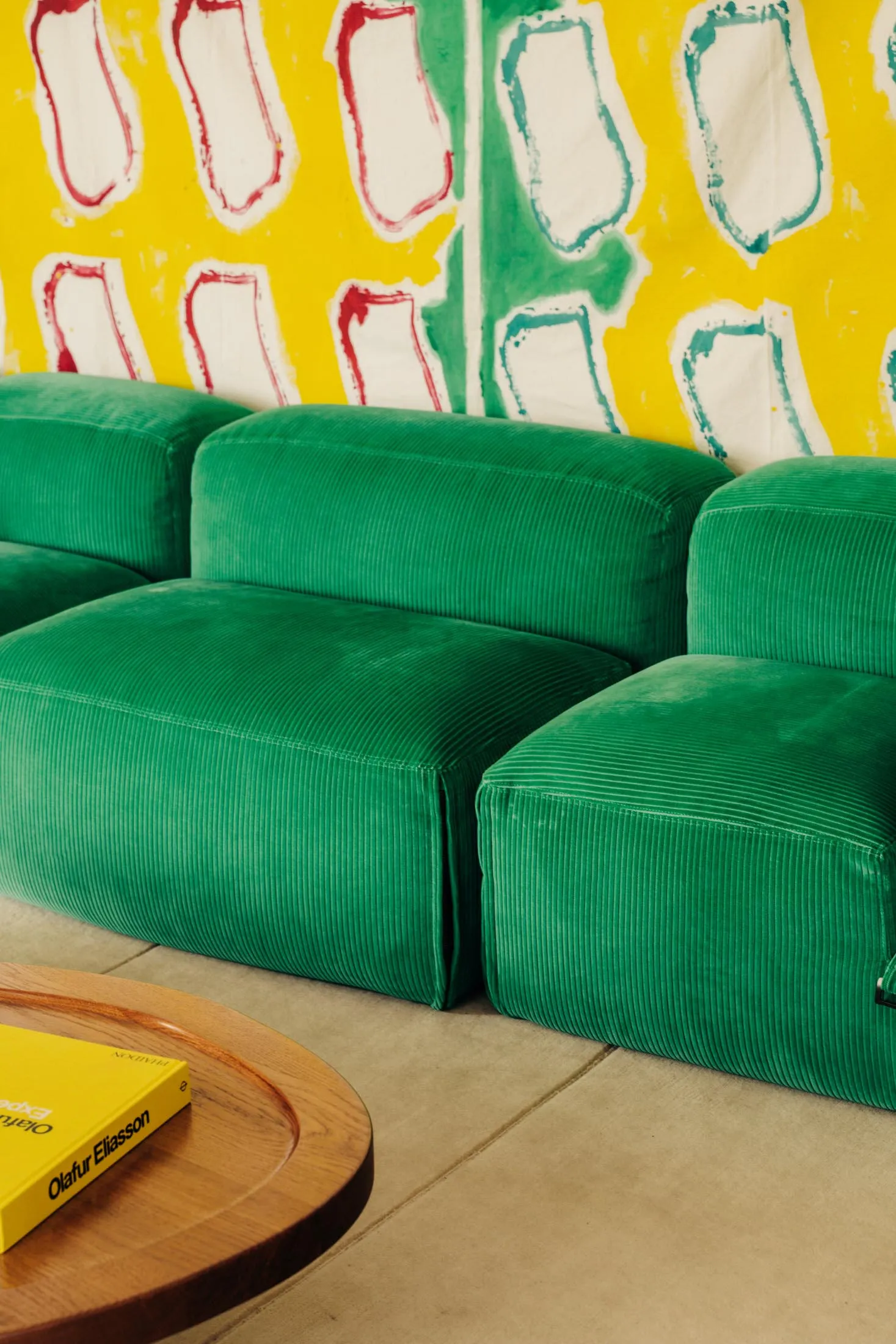 A modern, green corduroy velvet sofa in a contemporary living room setting.