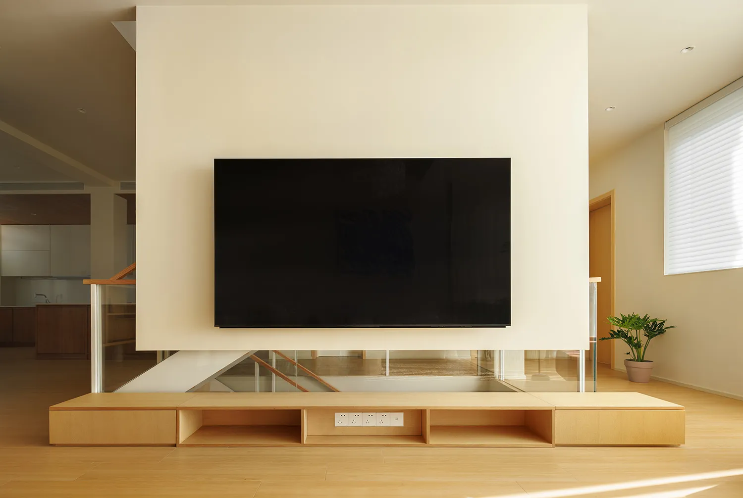 Modern living room with wooden furniture and a flat-screen TV.