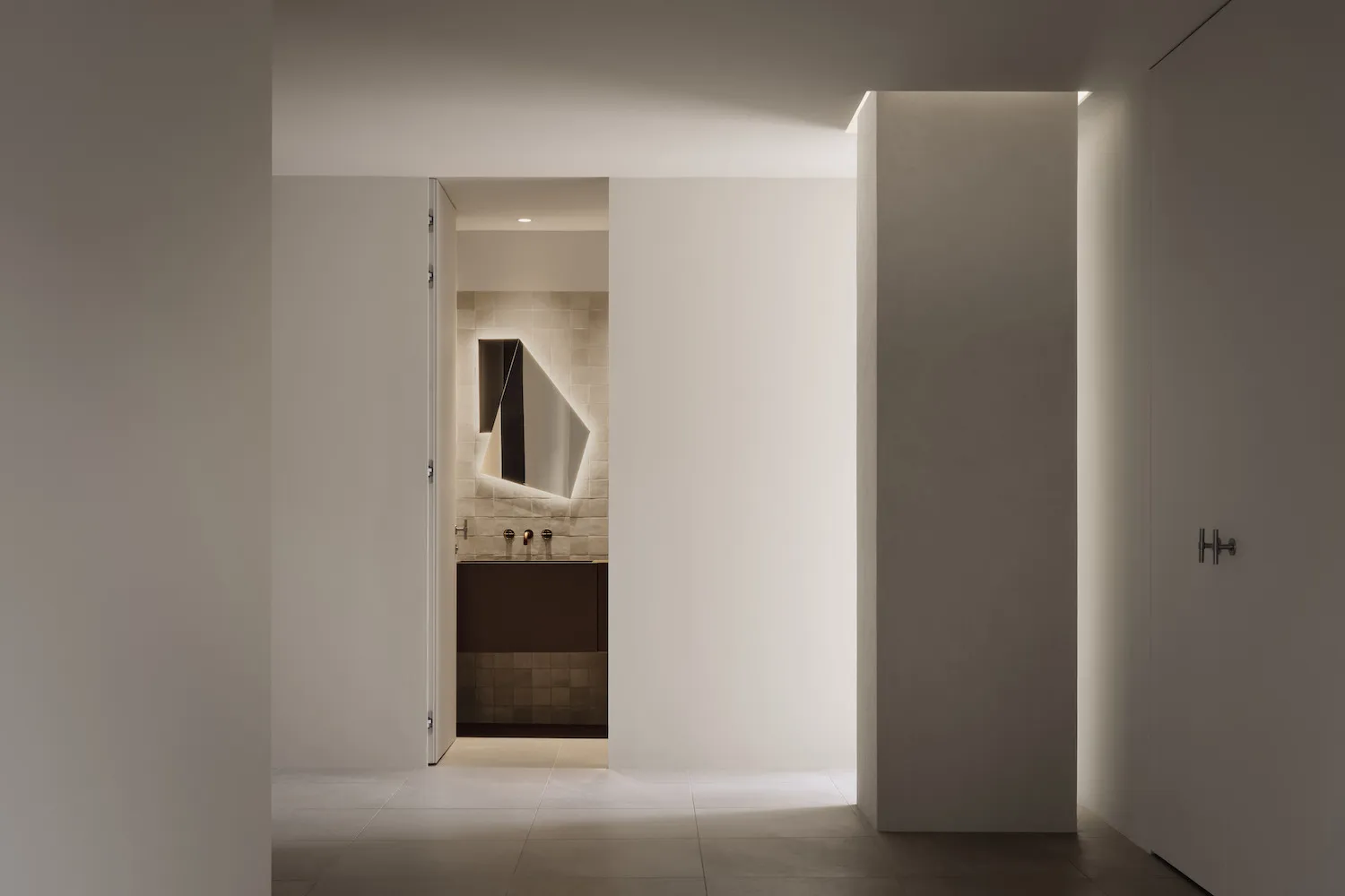 Minimalist bathroom with tiled walls and floor, featuring a sleek, contemporary design.